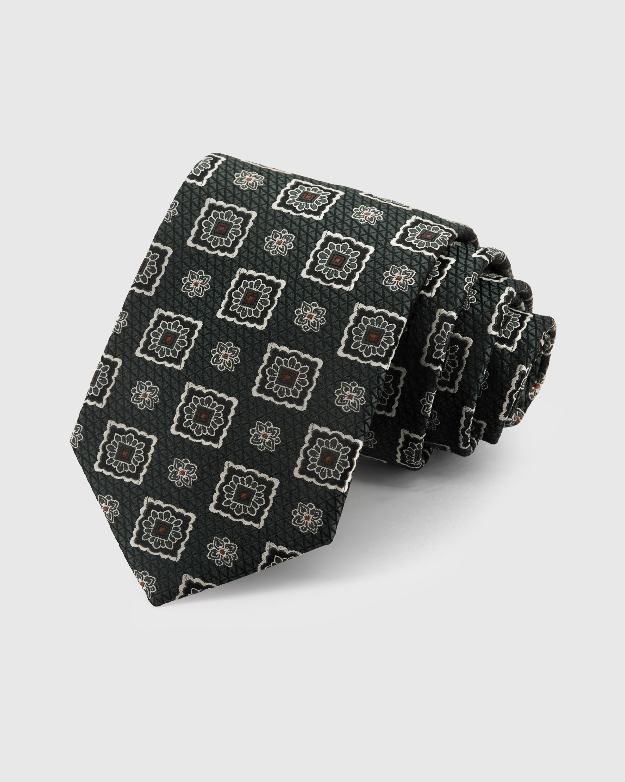 STICKYZOO Evergreen Medallion Tie in hand-embroidered mulberry silk with ornate cream-copper motifs on geometric ground, 45° bias-cut