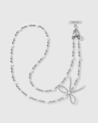 STICKYZOO cross-body phone strap laid full length: silver-tone balls, keshi faux-pearls, clear faceted beads, a woven silver-tone bow and dual clasps.