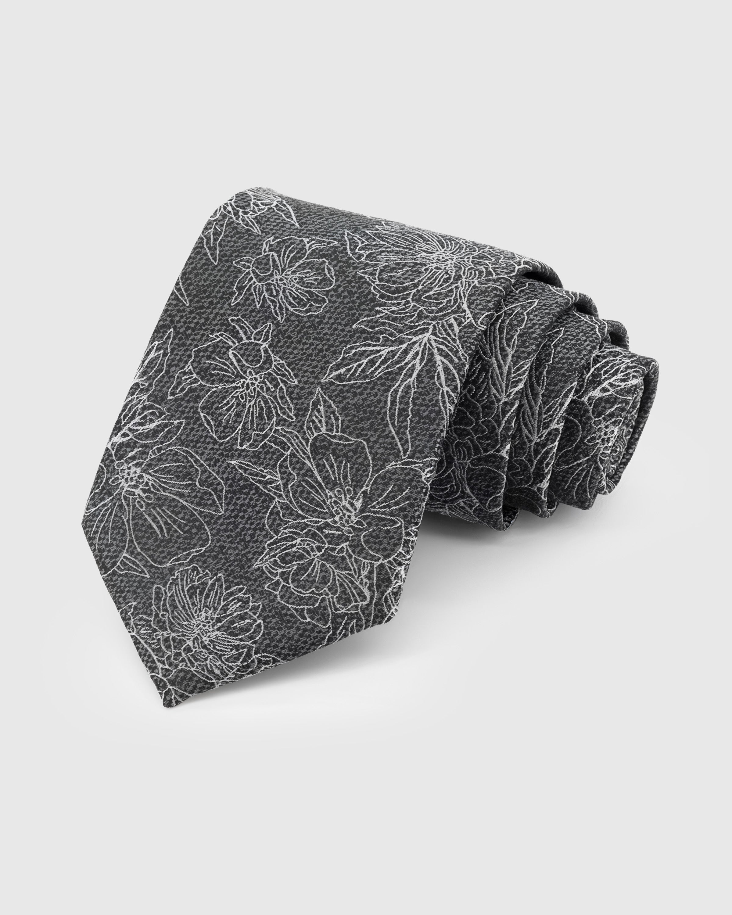 STICKYZOO Slate Botanical Tie in hand-embroidered mulberry silk with ivory botanical floral outlines on charcoal grey ground, 45° bias-cut