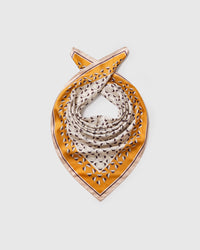 Silk petal scarf coiled to show the soft drape of the saffron field and the cream outer border