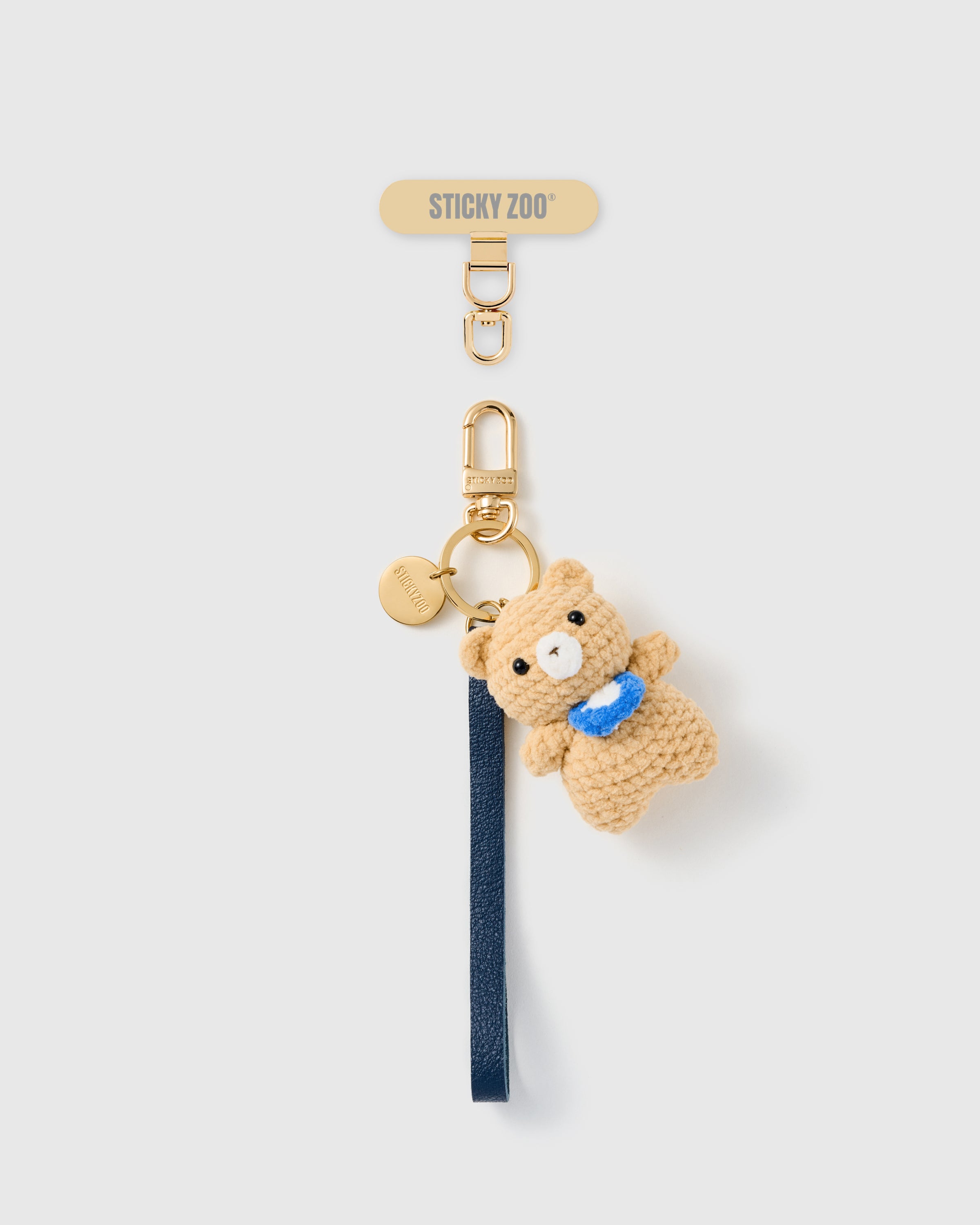 Handmade French Alran navy leather phone strap with hand-crochet camel teddy bear charm and 18K gold STICKYZOO hardware