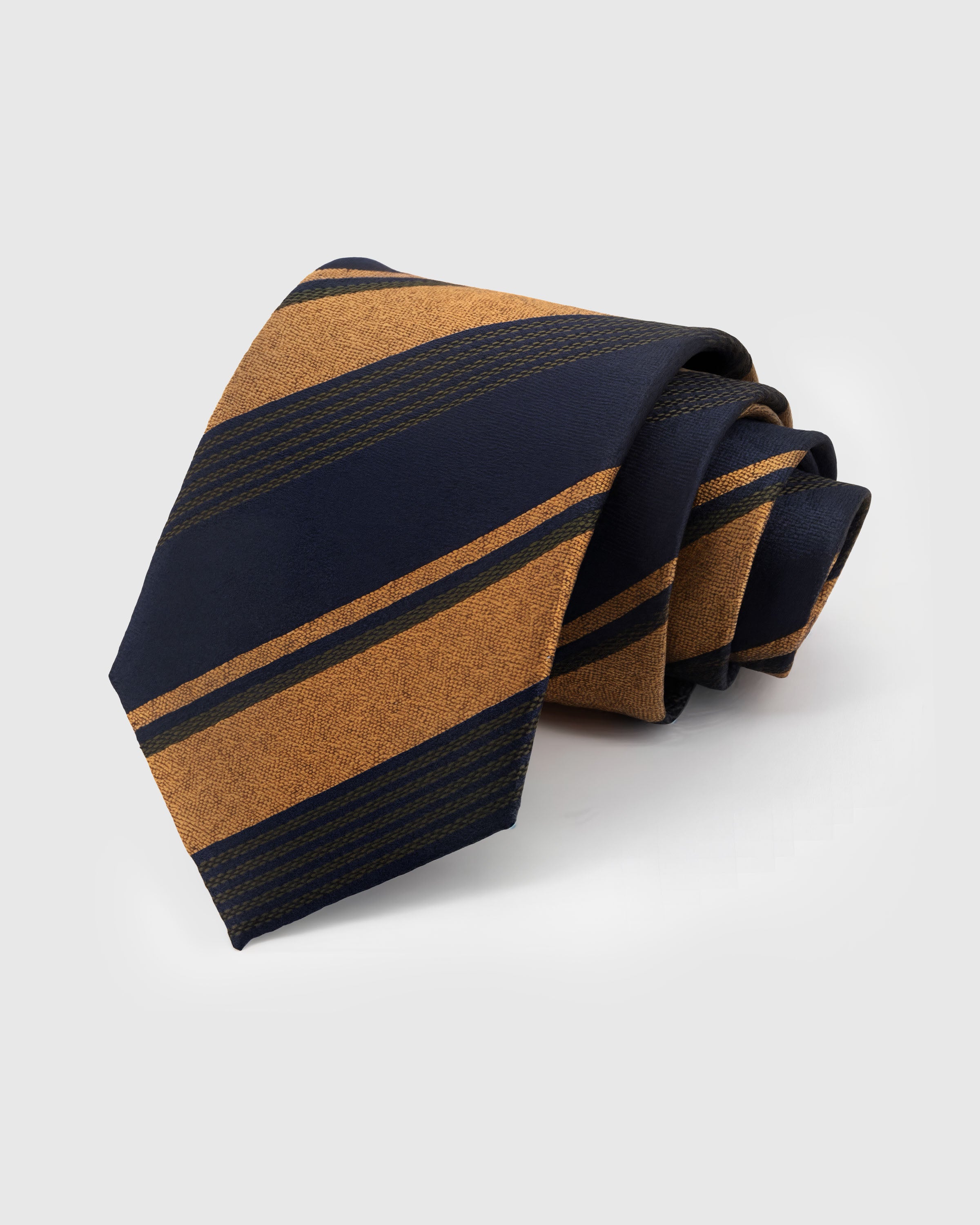 STICKYZOO Amber Club Tie in hand-embroidered mulberry silk with amber and midnight club stripes showing textured grain, 45° bias-cut Italian method