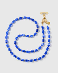STICKYZOO handmade cross-body phone strap in high-gloss cobalt-blue resin beads with white swirl, shown full length