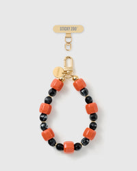 Handmade ember-orange and black beaded phone strap by STICKYZOO with 18K gold-plated engraved hardware