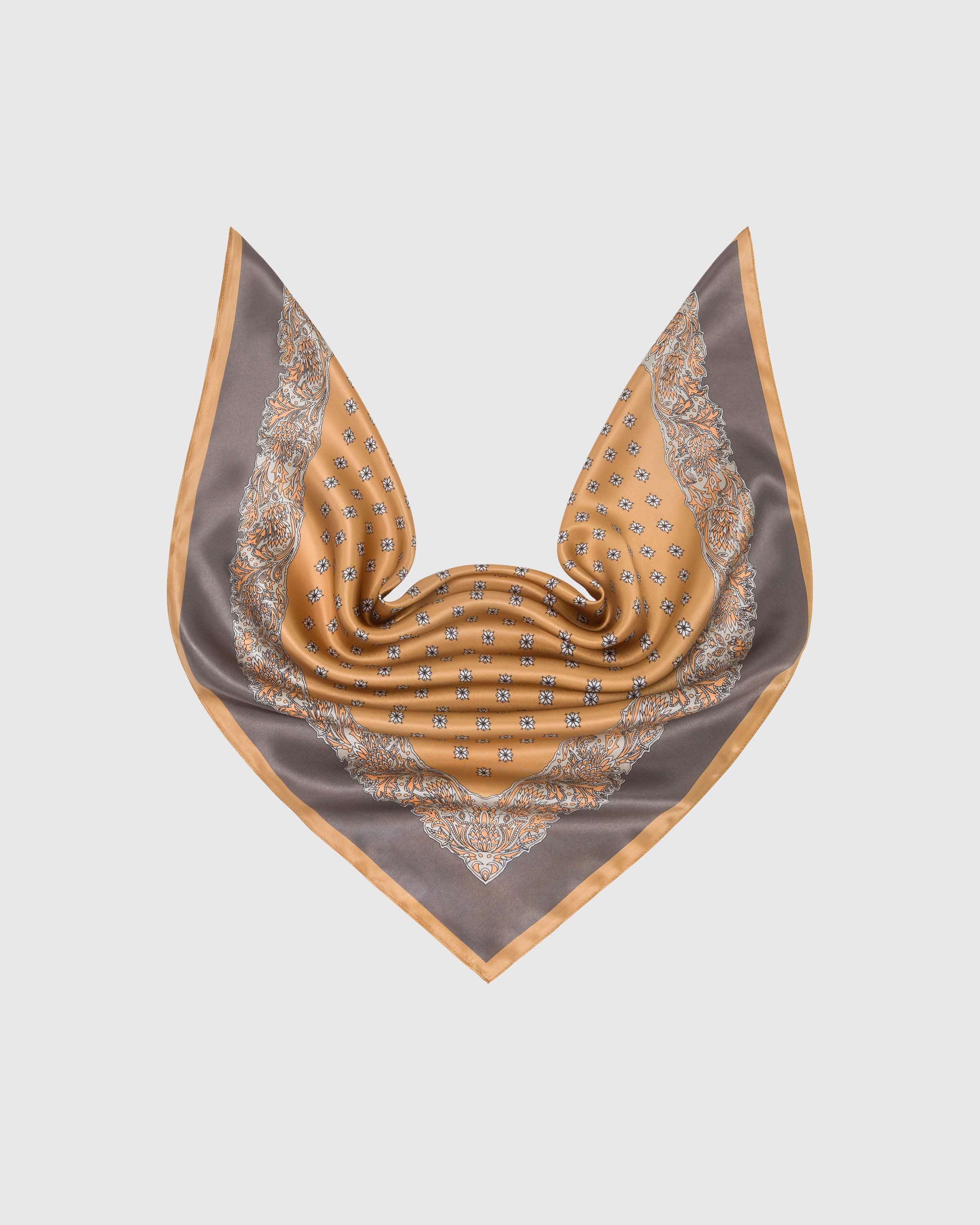 Amber silk scarf in a soft drape showing the foulard center and taupe paisley border framing