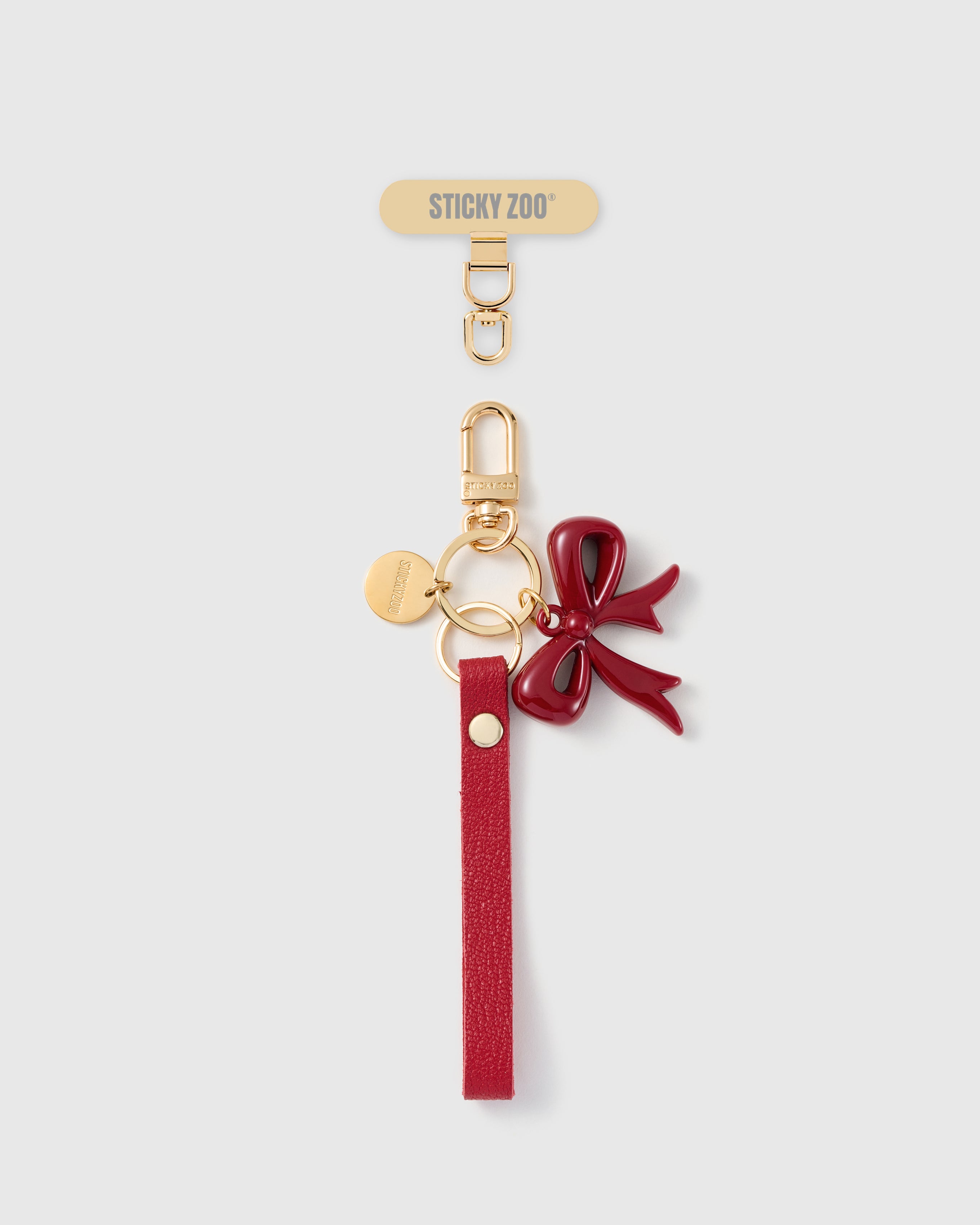 Handmade French Alran crimson red leather phone strap with deep ruby enamel bow charm and 18K gold STICKYZOO hardware