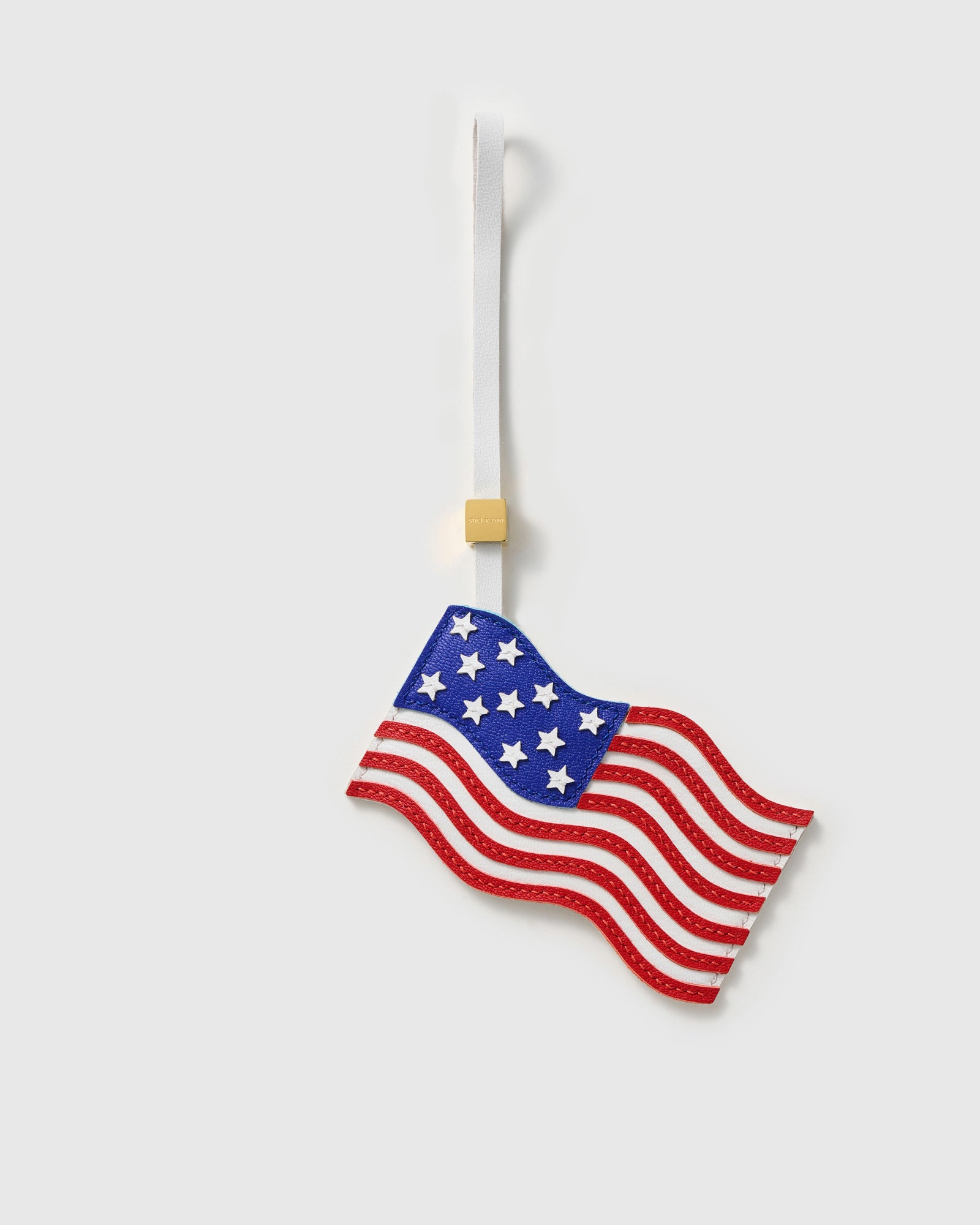 Handmade USA flag bag charm in French Alran leather — hand-cut stars and stripes in waving flag silhouette by STICKYZOO