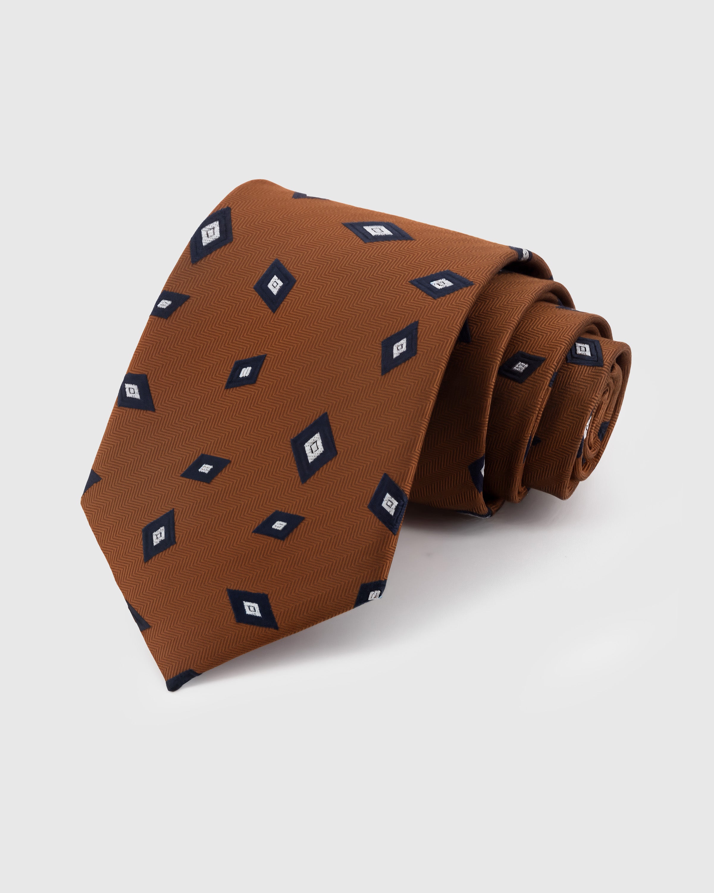 STICKYZOO Cognac Diamond Foulard Tie in hand-embroidered mulberry silk with navy diamond motifs on herringbone ground, 45° bias-cut