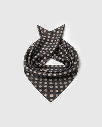 Silk coin scarf coiled to show the pure silk drape and the medallion repeat on obsidian black
