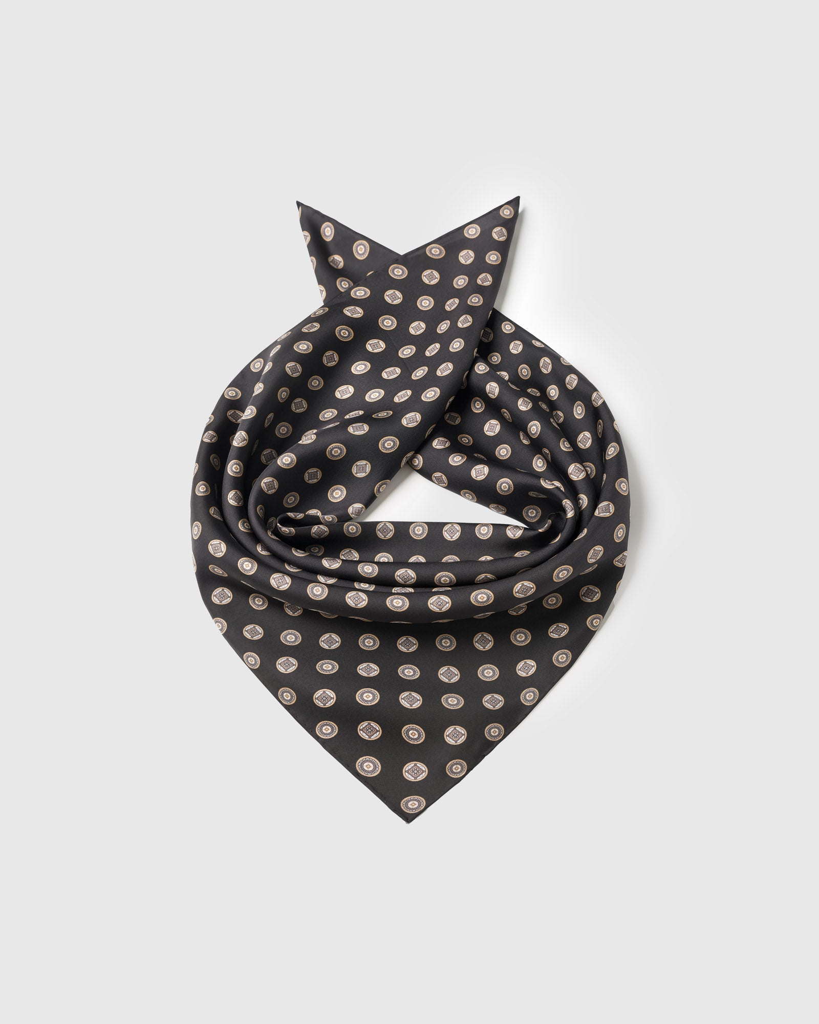 Silk coin scarf coiled to show the pure silk drape and the medallion repeat on obsidian black