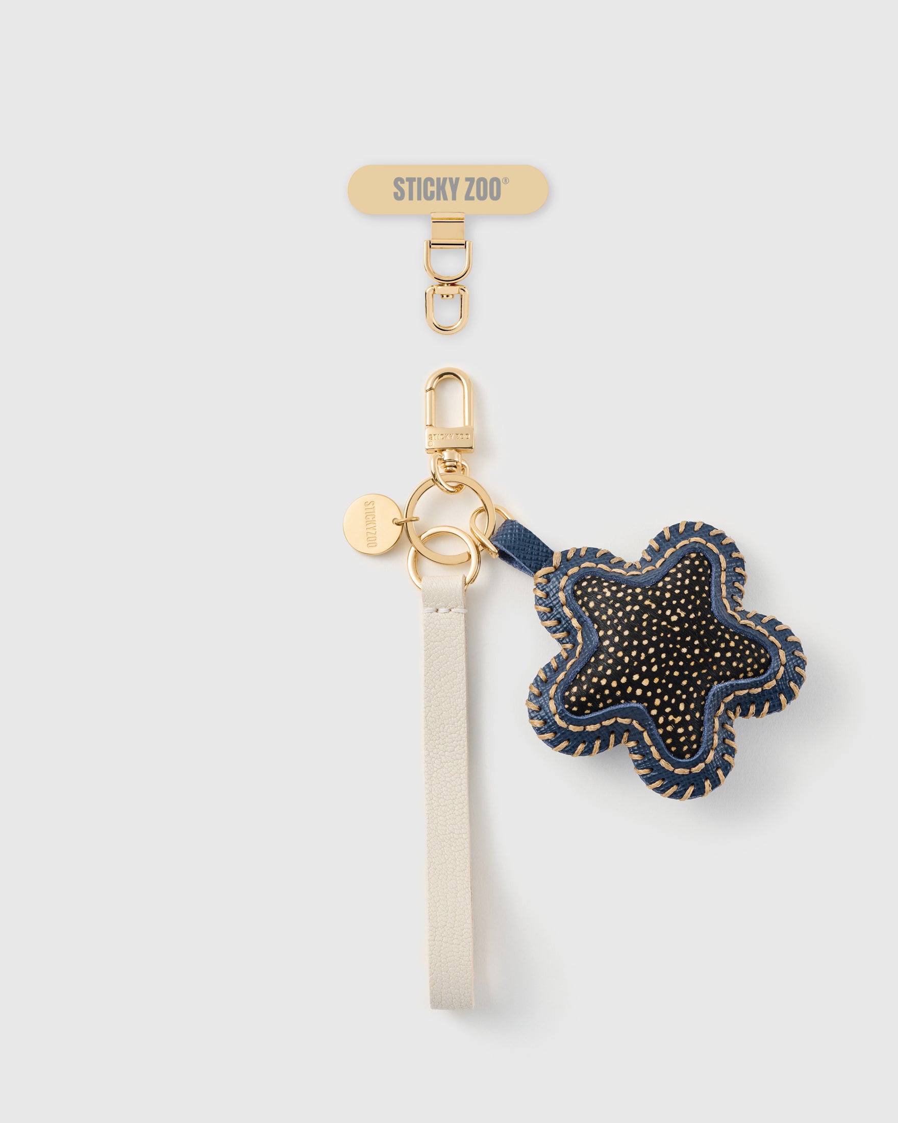 STICKYZOO midnight spotted star leather phone strap — gold-flecked calf-hair star in navy leather, ivory Alran strap, gold hardware
