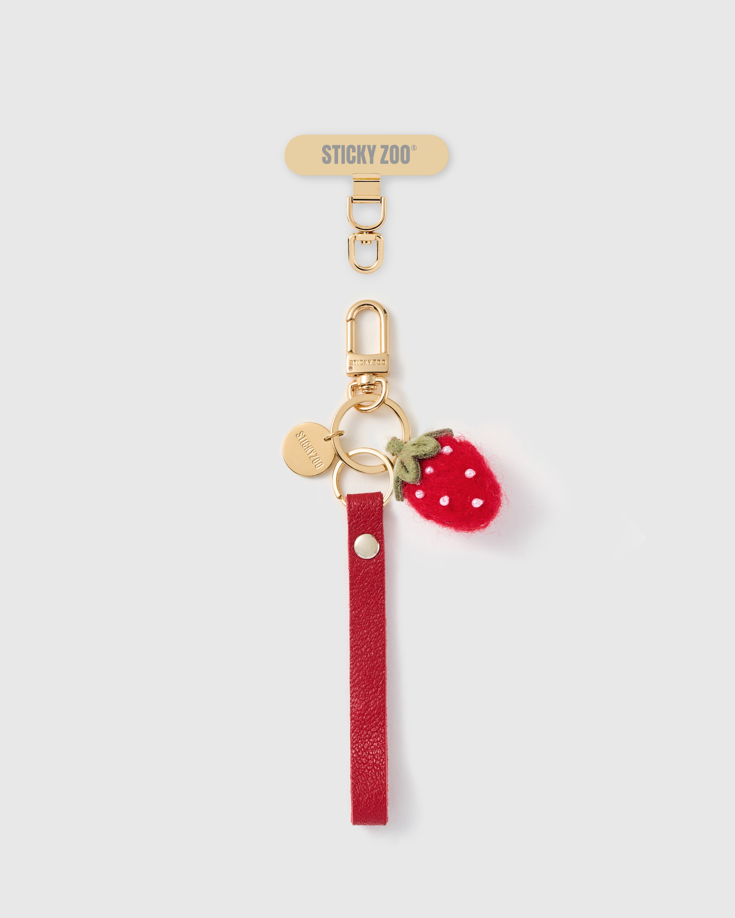 Handmade French Alran crimson red leather phone strap with hand-felted wool strawberry charm and 18K gold STICKYZOO hardware