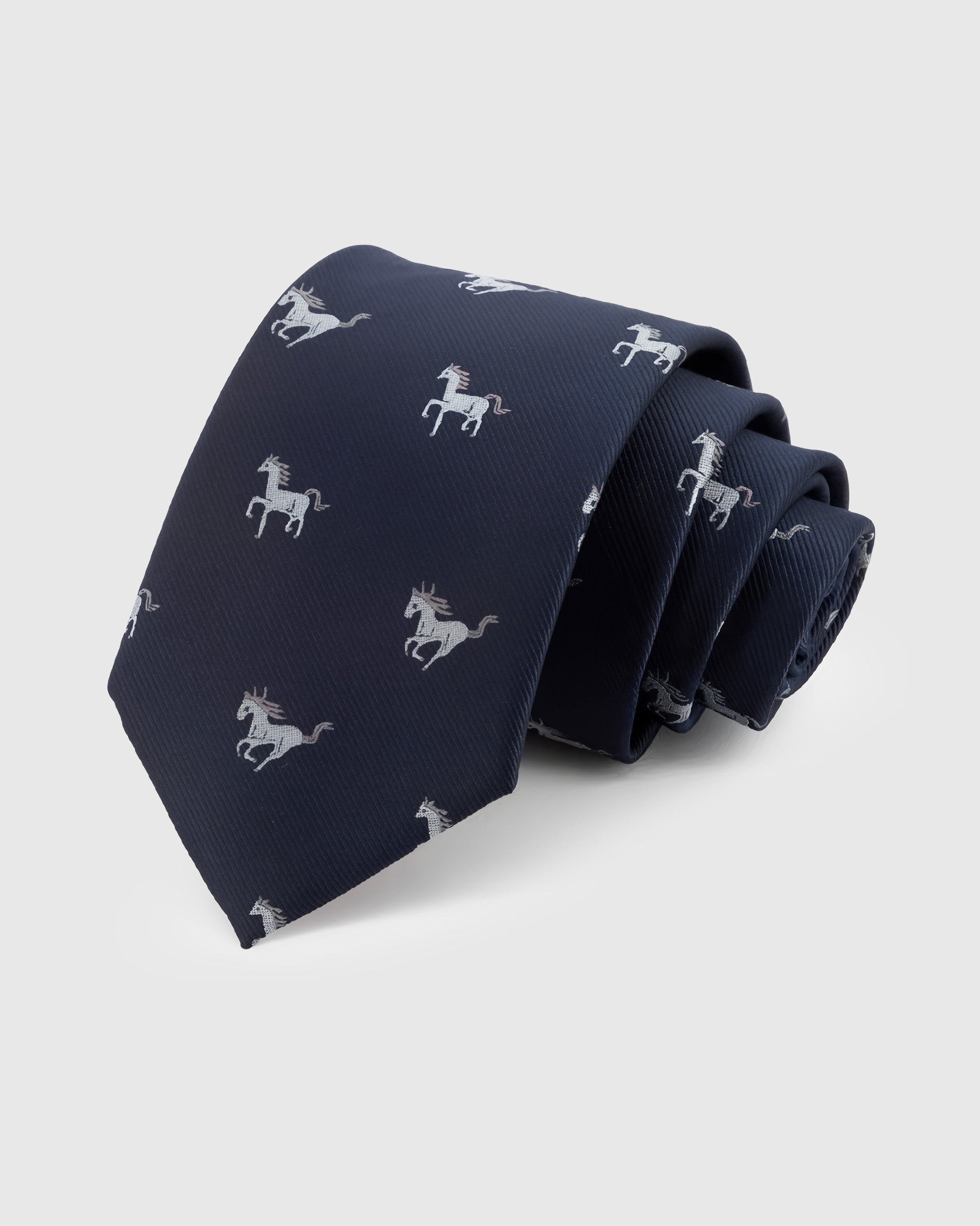 NAVY STALLION TIE — Hand-embroidered horse detail on 100% mulberry silk in navy, showing embroidery texture and silk sheen