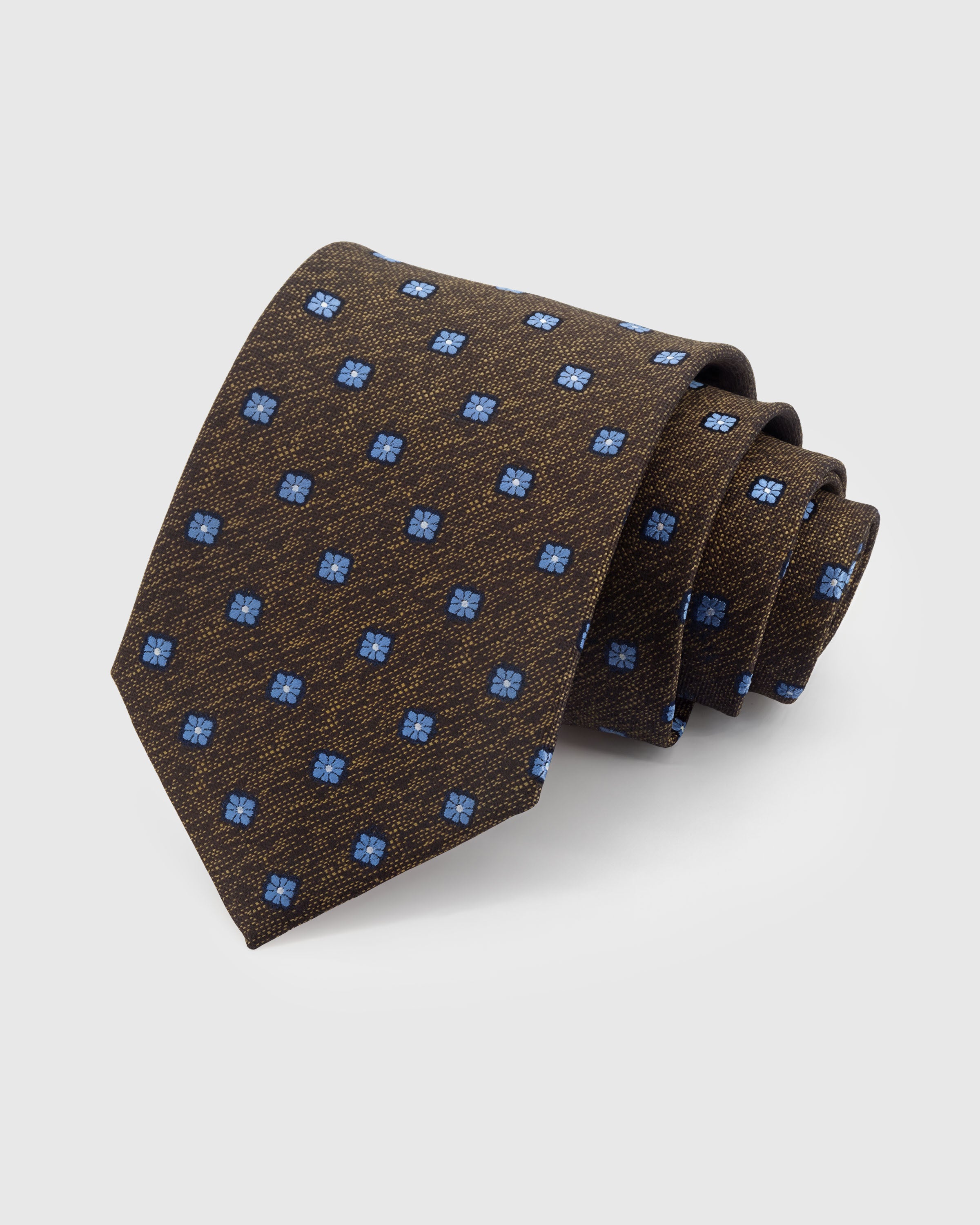 STICKYZOO ESPRESSO FLORET TIE — 100% mulberry silk with hand-embroidered cornflower blue four-petal floret motifs on dark espresso brown with heathered weave ground