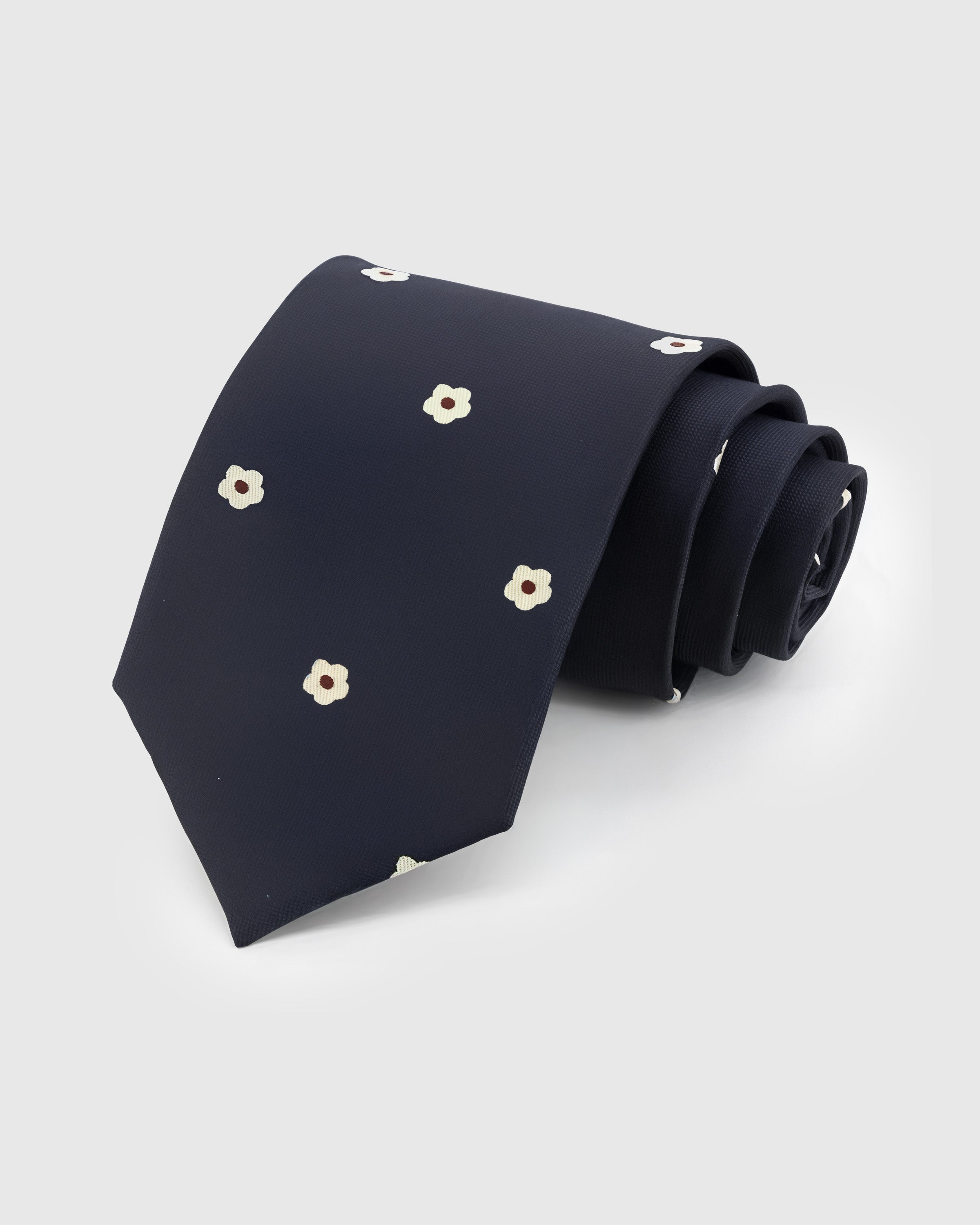 MIDNIGHT BLOSSOM TIE — Hand-embroidered floral detail on 100% mulberry silk in midnight navy, showing embroidery texture and silk sheen