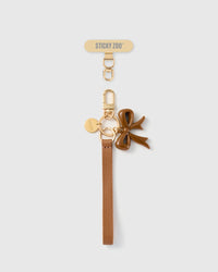 Handmade French Alran hazel tan leather phone strap with glossy cocoa enamel bow charm and 18K gold STICKYZOO hardware