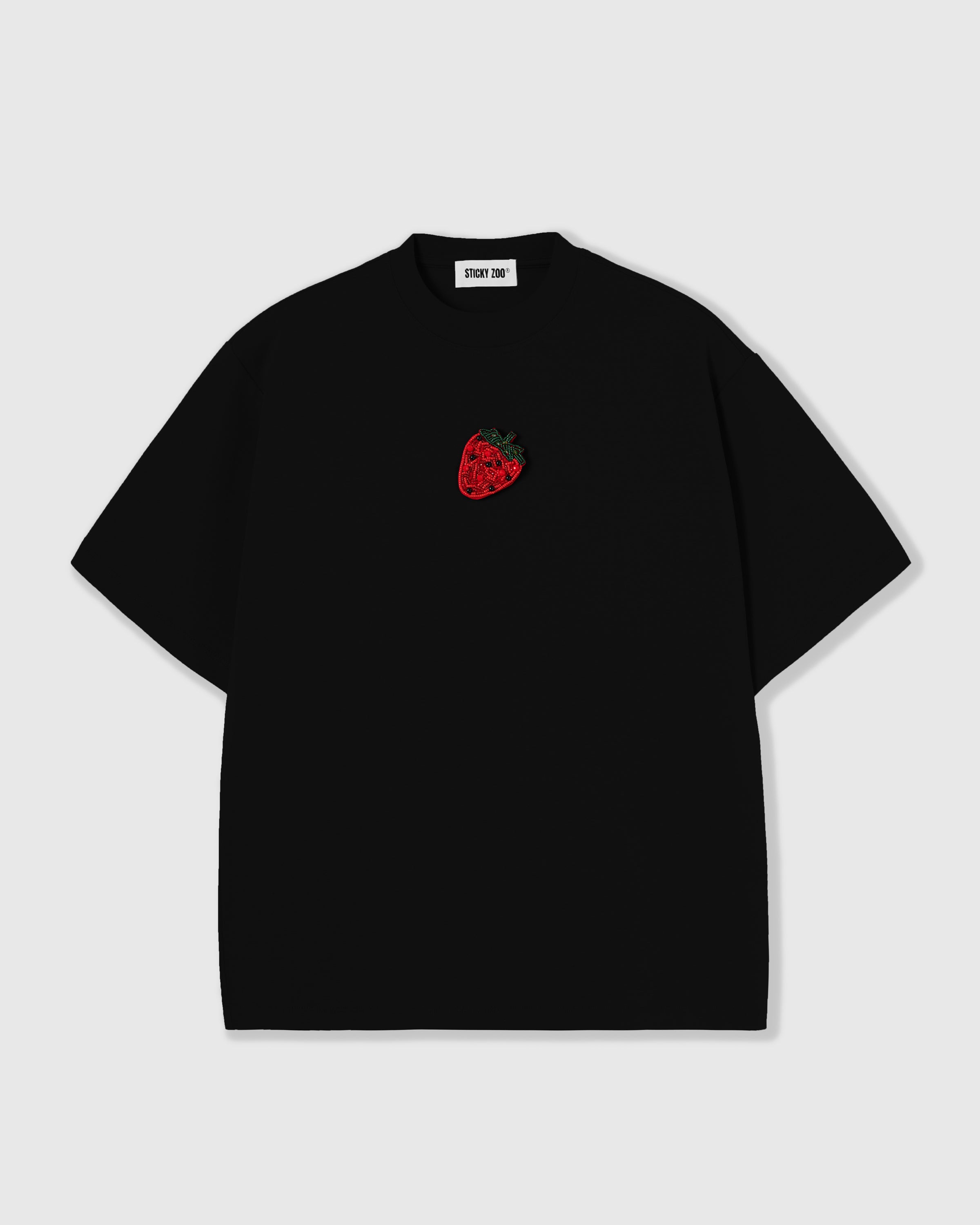 STICKYZOO Strawberry T-Shirt in black, oversized boxy fit with a hand-beaded glass strawberry on the left chest and dropped shoulders.