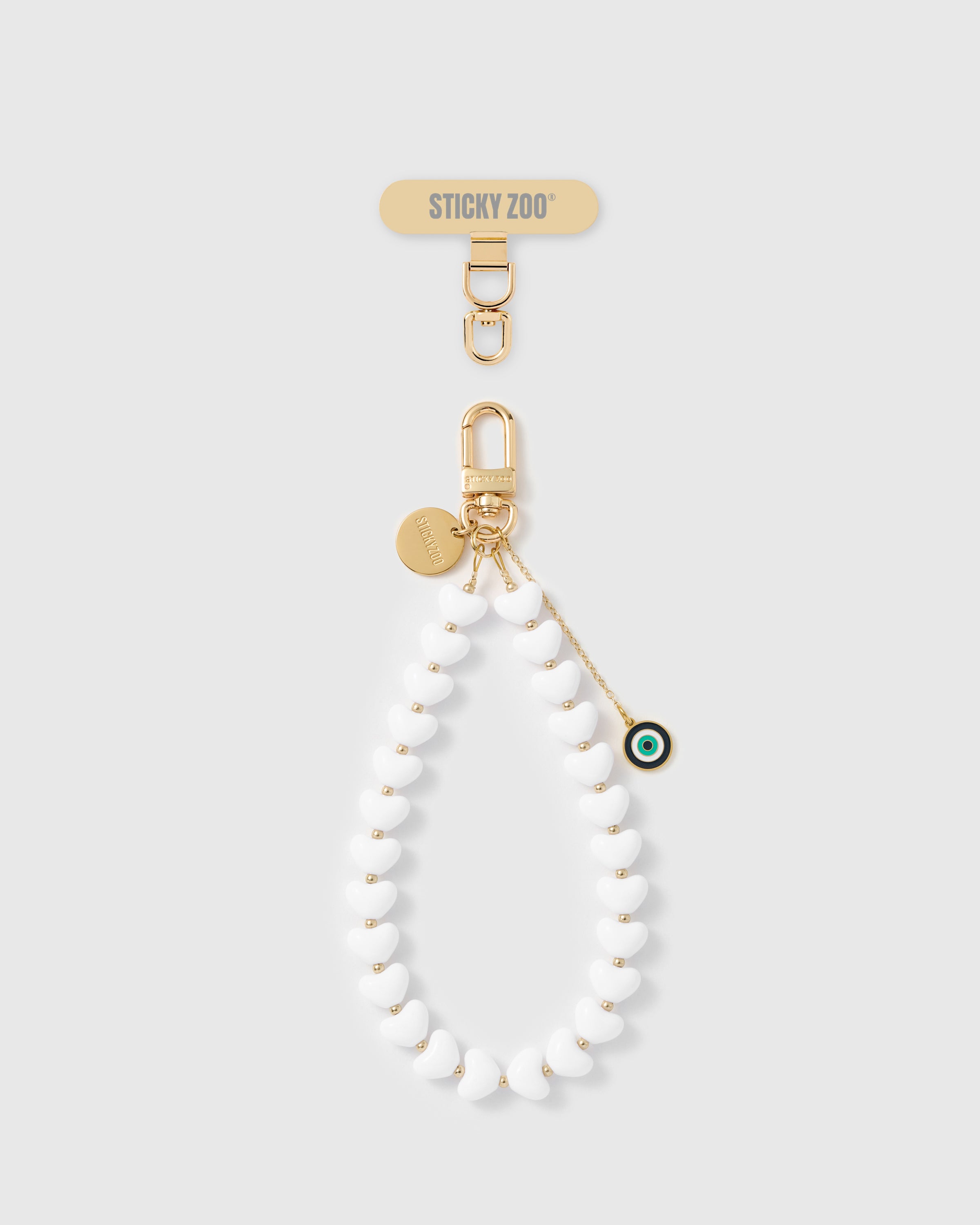 Handmade white heart bead phone strap with green and navy mati eye amulet and 18K gold engraved STICKYZOO hardware