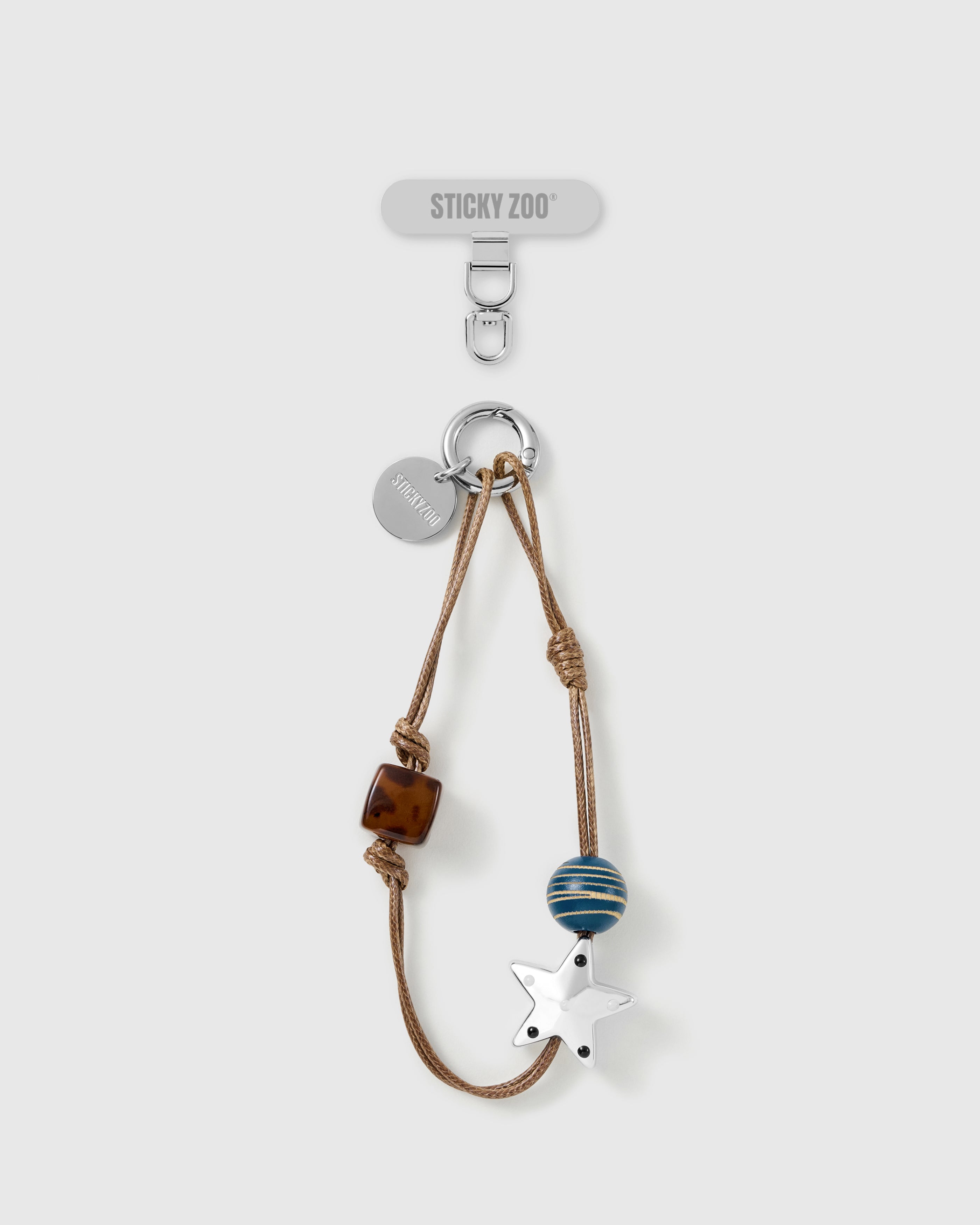 Beaded wrist phone strap: silver star and tortoiseshell beads on tan cord, with silver-tone hook, engraved STICKYZOO disc and phone strap card.