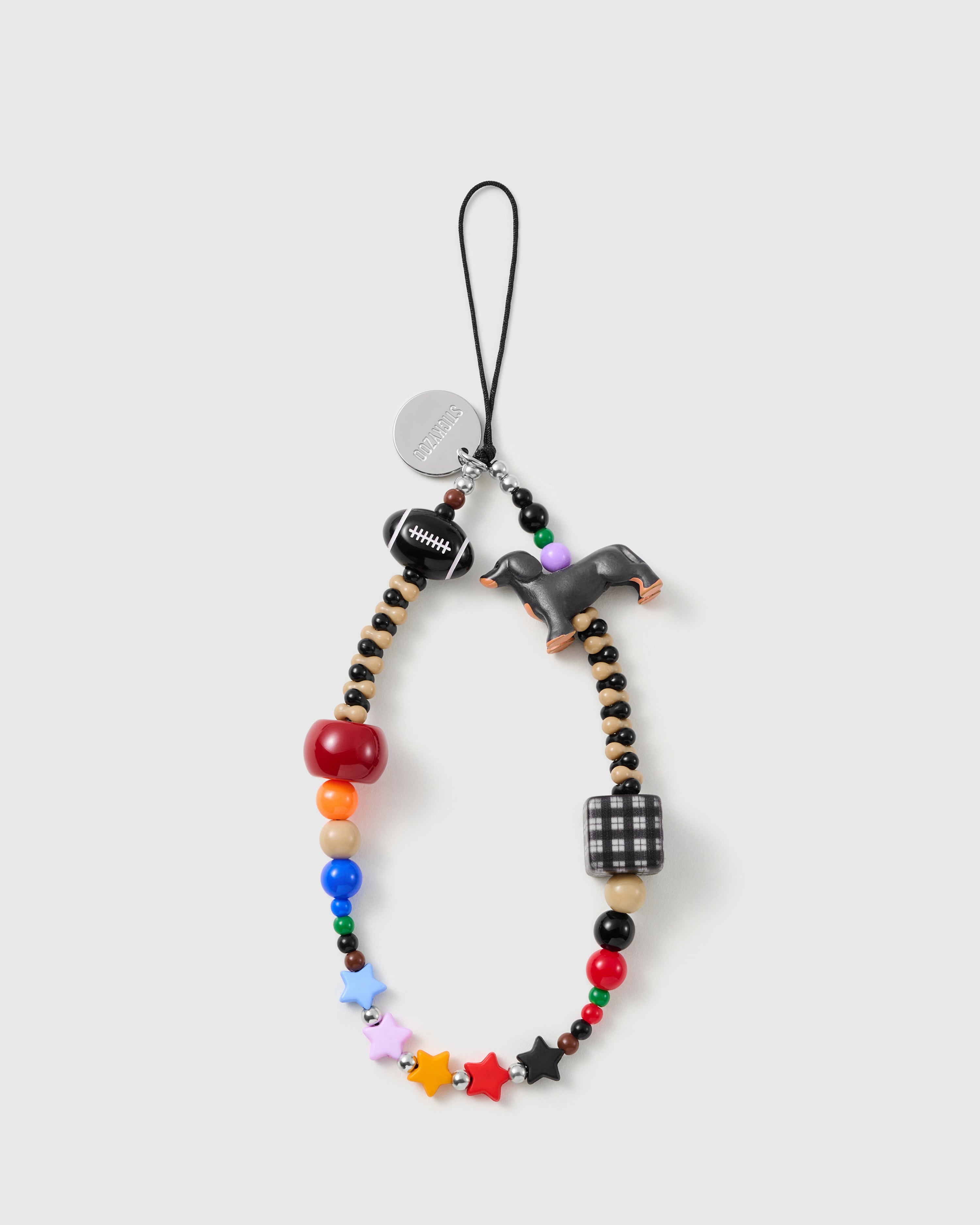 STICKYZOO beaded phone strap laid flat: multicolour beads, black-and-tan dachshund charm, football bead, gingham cube and star beads on a black cord loop.
