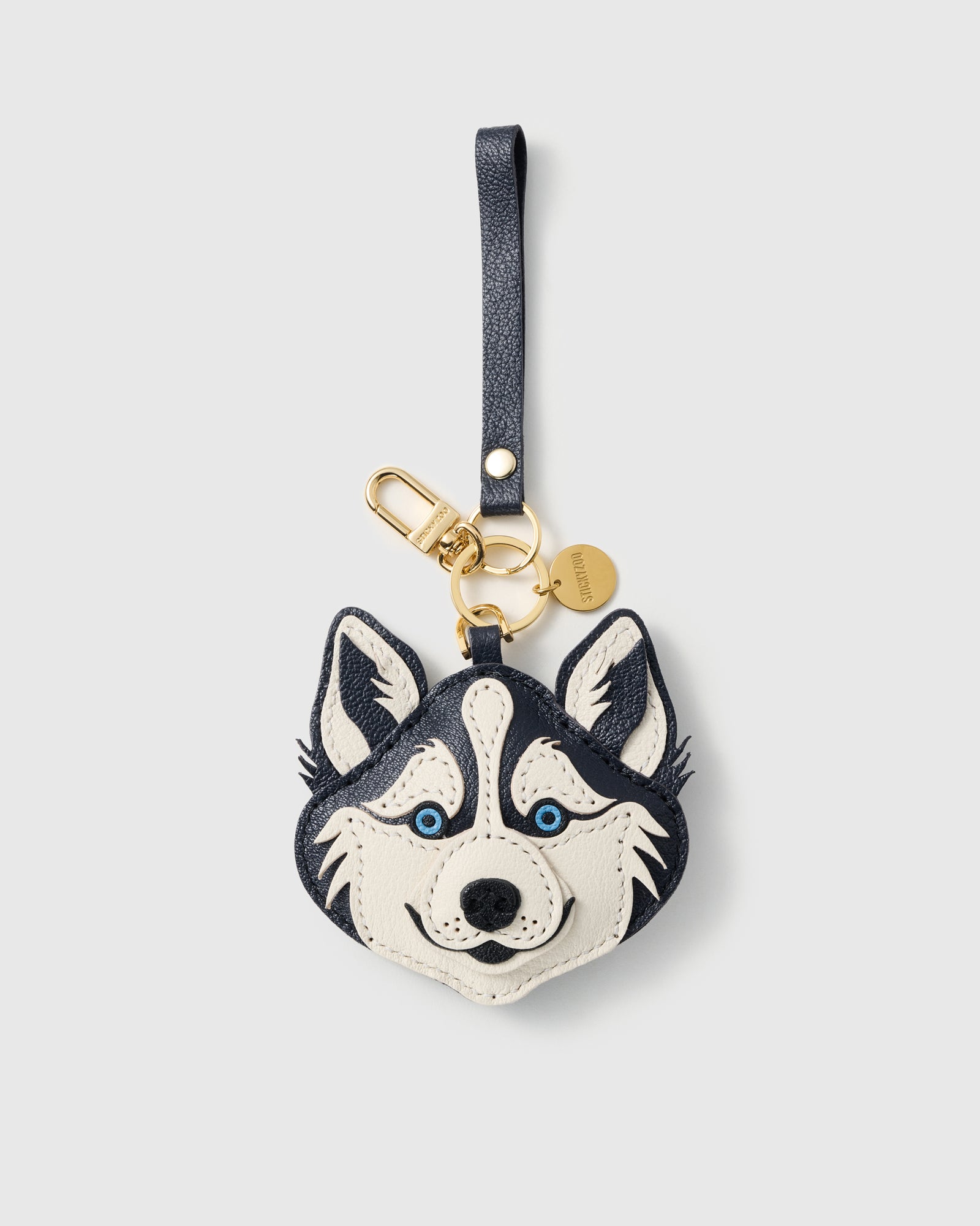 {{18K gold-plated hardware}} Husky charm with gold keychain clasp, split ring, engraved STICKYZOO coin, and leather wrist strap