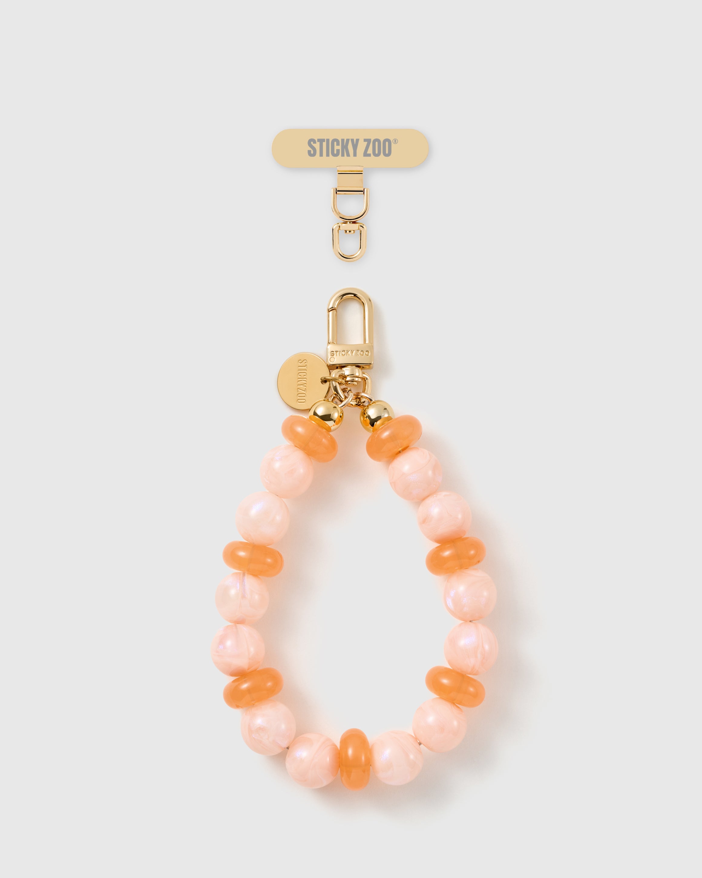 Handmade peach pearl beaded phone strap by STICKYZOO with 18K gold-plated engraved hardware