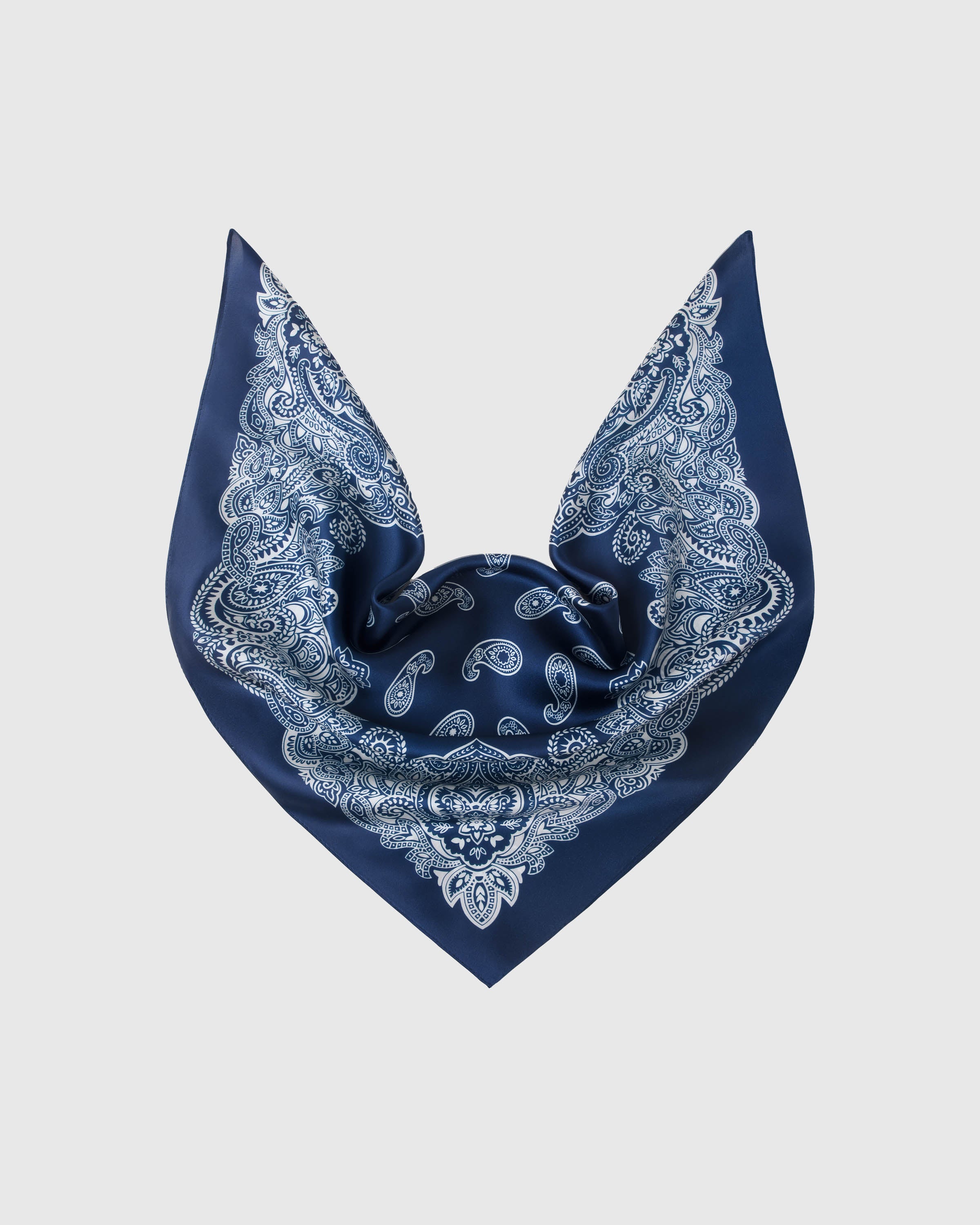 Indigo silk scarf opened into a triangular drape showing the corner paisley medallions and central field