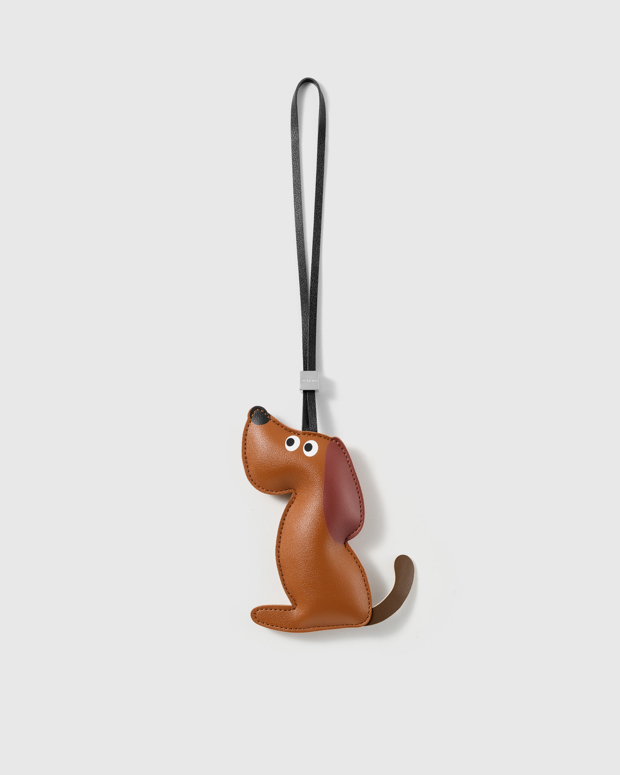 Handmade French Alran leather sitting puppy bag charm with engraved 18K gold-plated hardware by STICKYZOO
