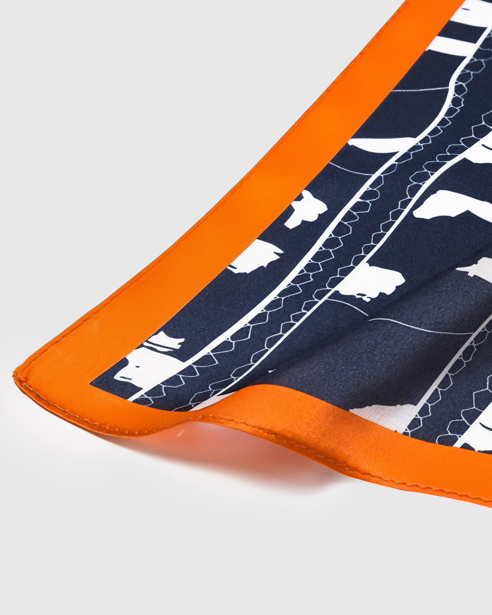 Close-up of the tangerine orange border meeting the navy print on pure silk