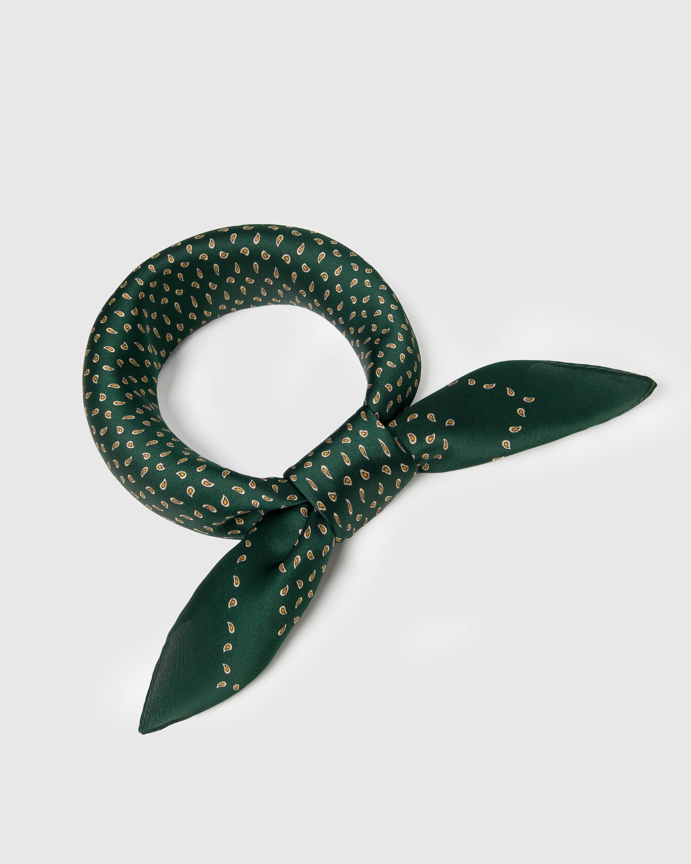 Emerald silk scarf knotted into a ring showing how the gold paisley print drapes around the neck