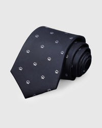 100% mulberry silk STICKYZOO Paw Mark Tie in dark navy with hand-embroidered white paw print motifs, rolled to show silk texture