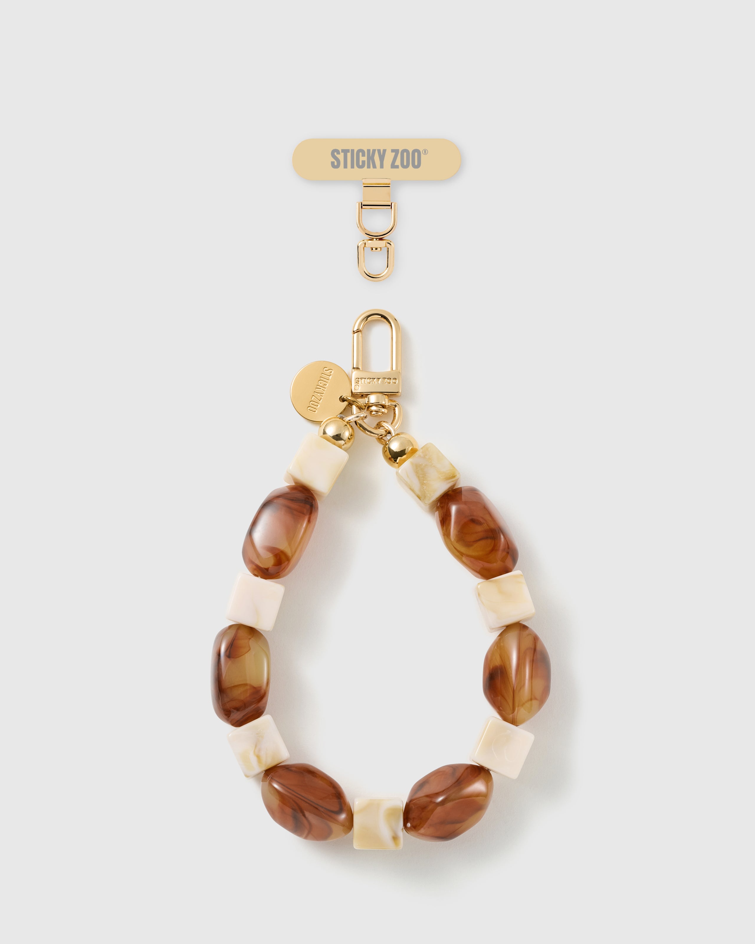 Handmade cognac marbled bead phone strap by STICKYZOO with 18K gold-plated engraved hardware