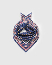 Silk foulard scarf coiled to show the drape of pure silk and the mustard diamond motif