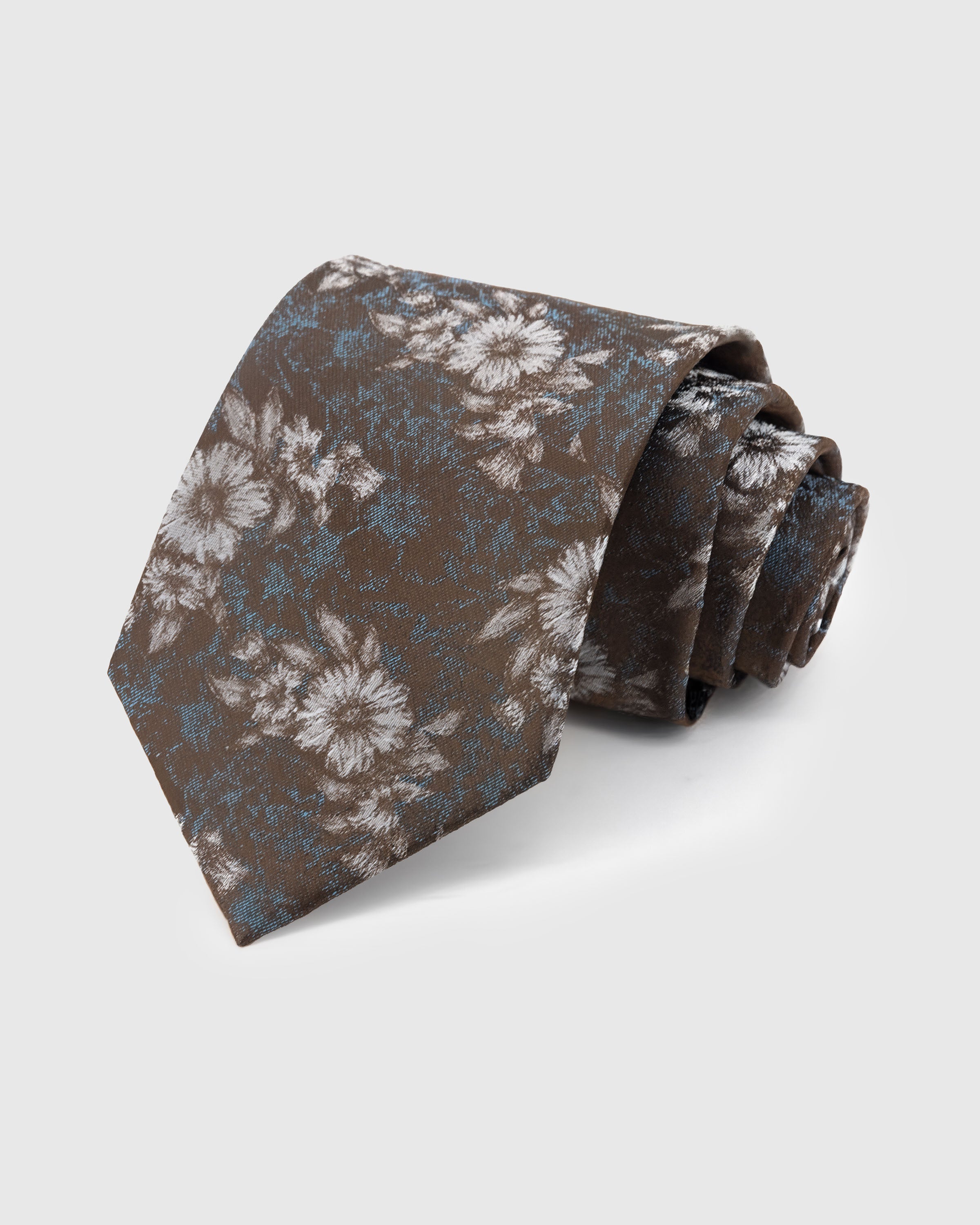 UMBER FLORAL TIE — Hand-embroidered floral detail on 100% mulberry silk in umber, showing embroidery texture and silk sheen