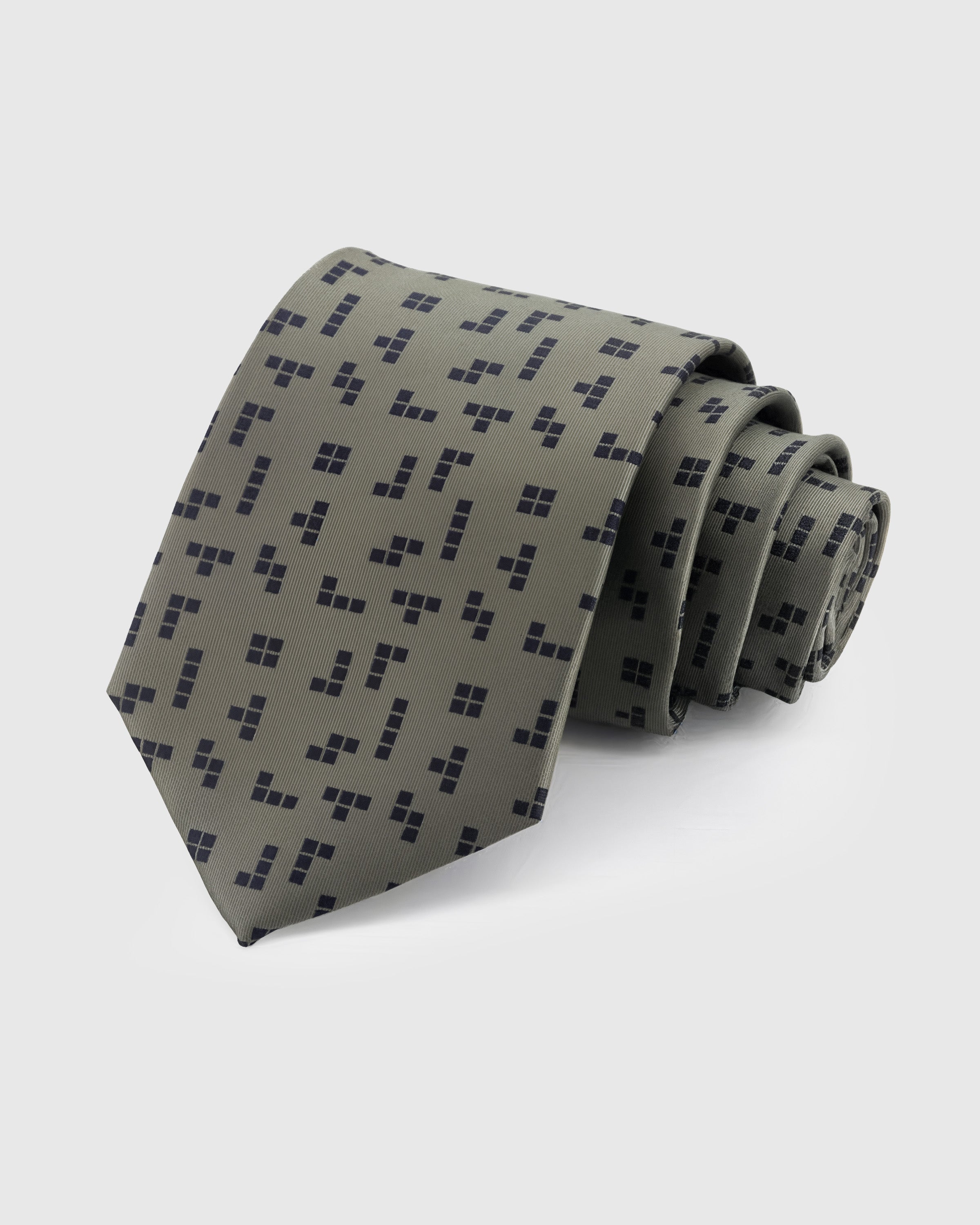 STICKYZOO Sage Geometric Tie in hand-embroidered mulberry silk with navy geometric square clusters on muted olive-green ground, 45° bias-cut