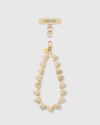 Marbled ivory heart bead phone strap laid straight, with a gold hook, an engraved gold disc, and a STICKYZOO phone-strap card at the top.