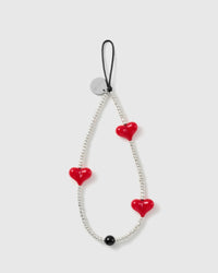 STICKYZOO beaded phone strap laid flat, a full loop of silver-tone seed beads with three glossy red hearts, one black bead and a silver disc.