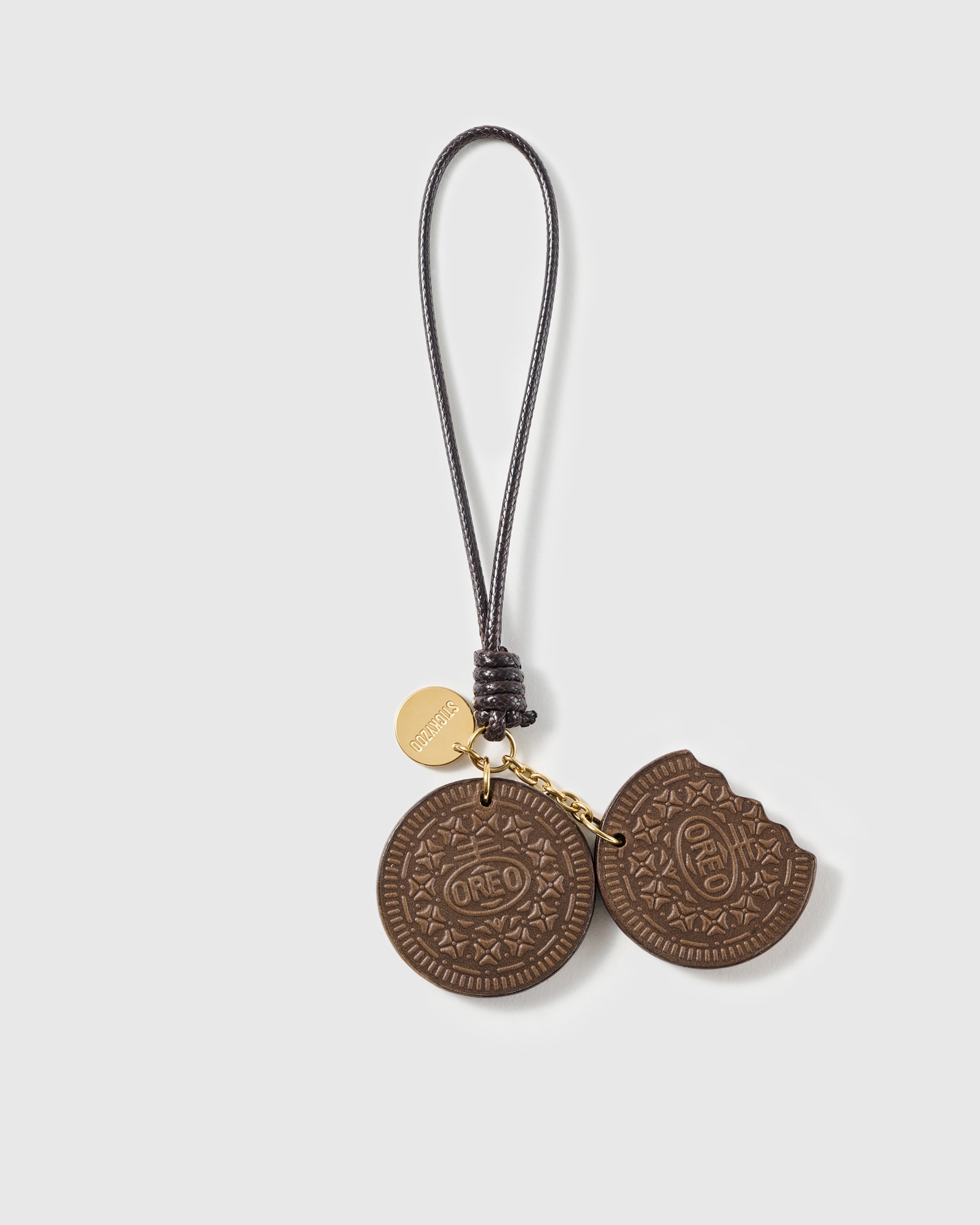 Handmade French Alran goatskin leather sandwich cookie bag charm with embossed pattern and engraved STICKYZOO gold disc