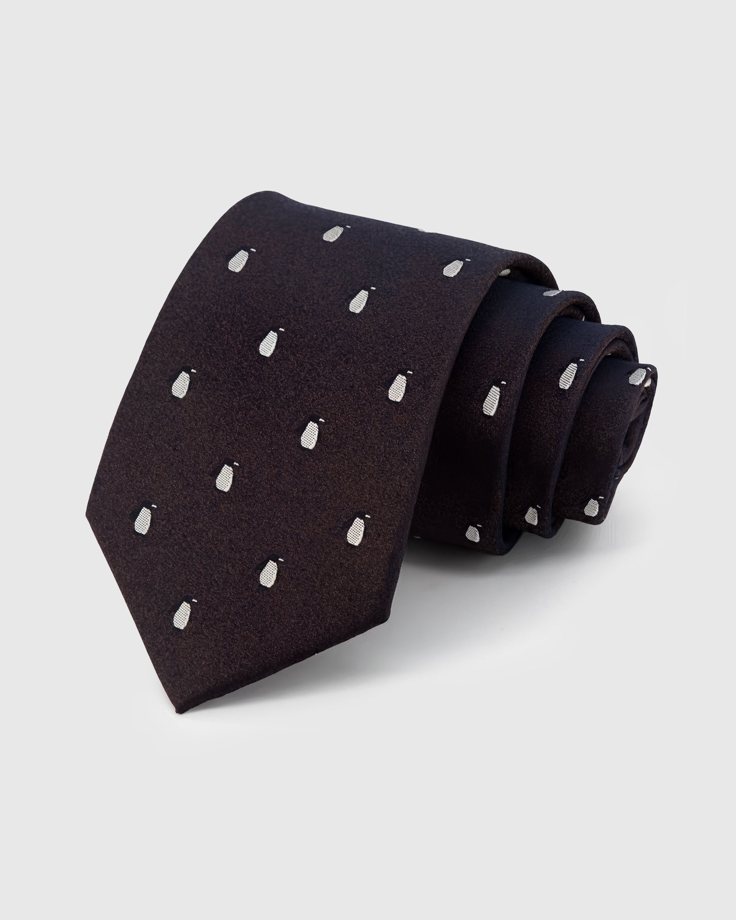 STICKYZOO Onyx Penguin Tie in hand-embroidered mulberry silk with white penguin motifs on onyx textured ground, 45° bias-cut Italian method