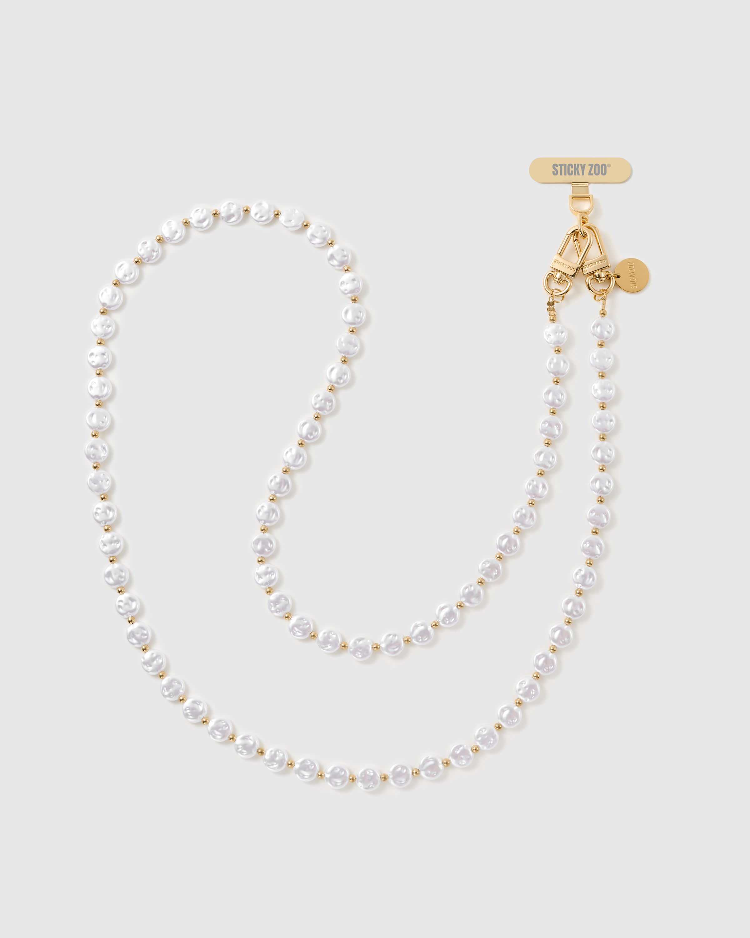 STICKYZOO cross-body phone strap laid full length: white faux-pearls with gold-tone spacer beads and a gold dual clasp with engraved Phone Strap Card.