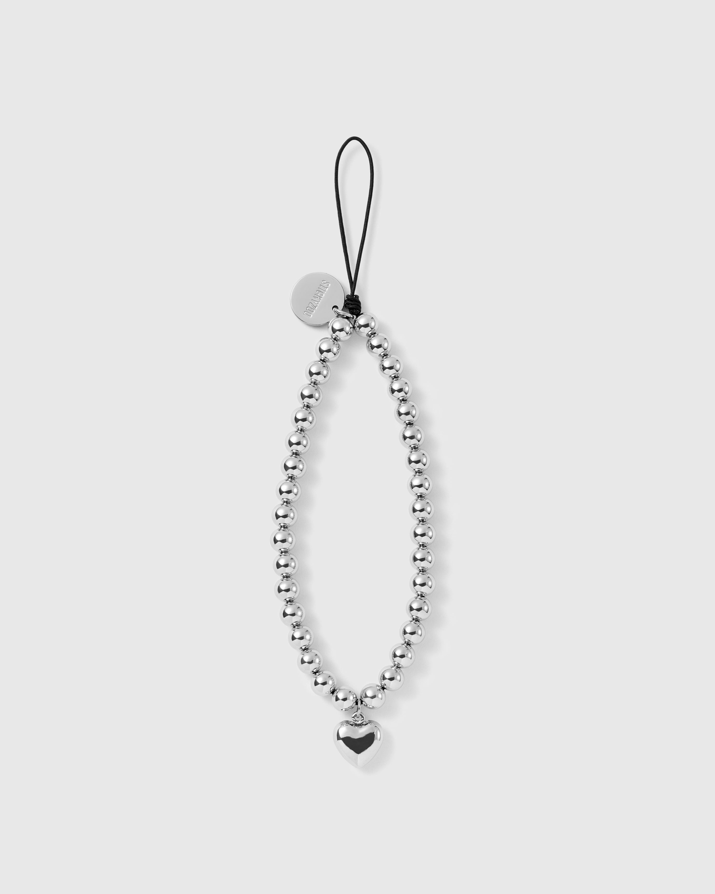 STICKYZOO silver-tone beaded phone strap laid flat, a full loop of round beads with one puffy heart drop and a black cord loop up top