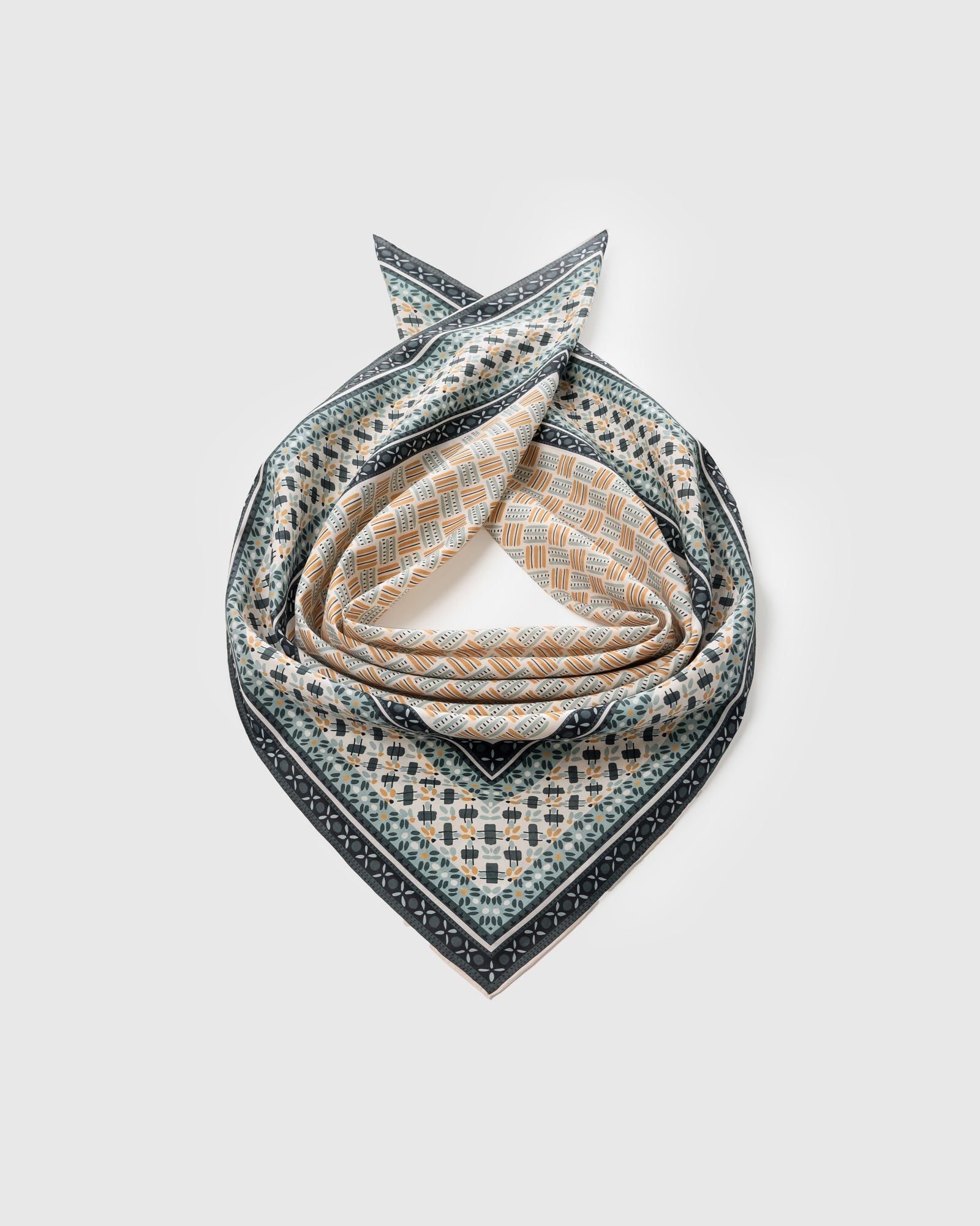 Silk mosaic scarf coiled to show the central tile field and concentric geometric borders