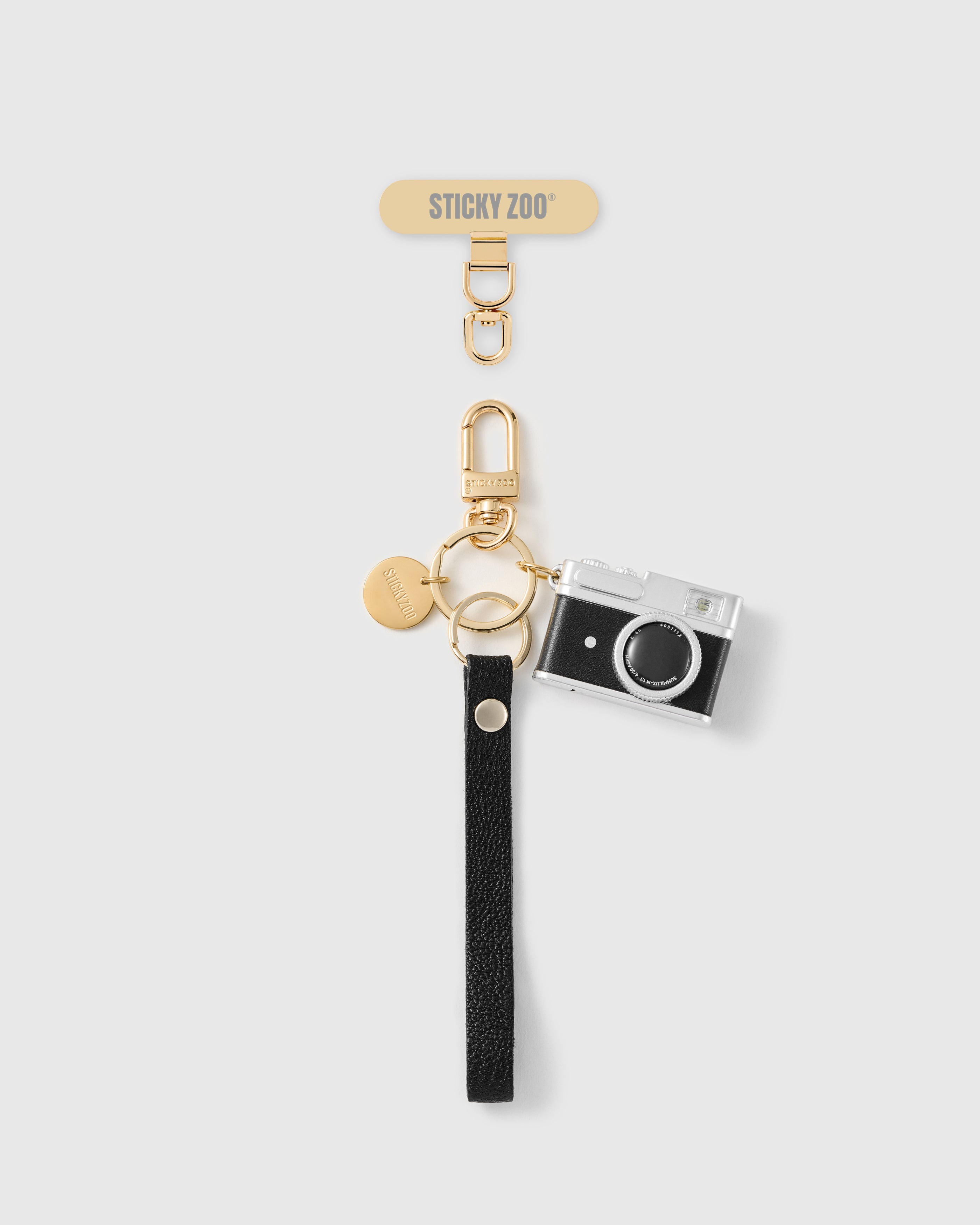 Handmade French Alran black leather phone strap with mini camera charm and 18K gold STICKYZOO hardware