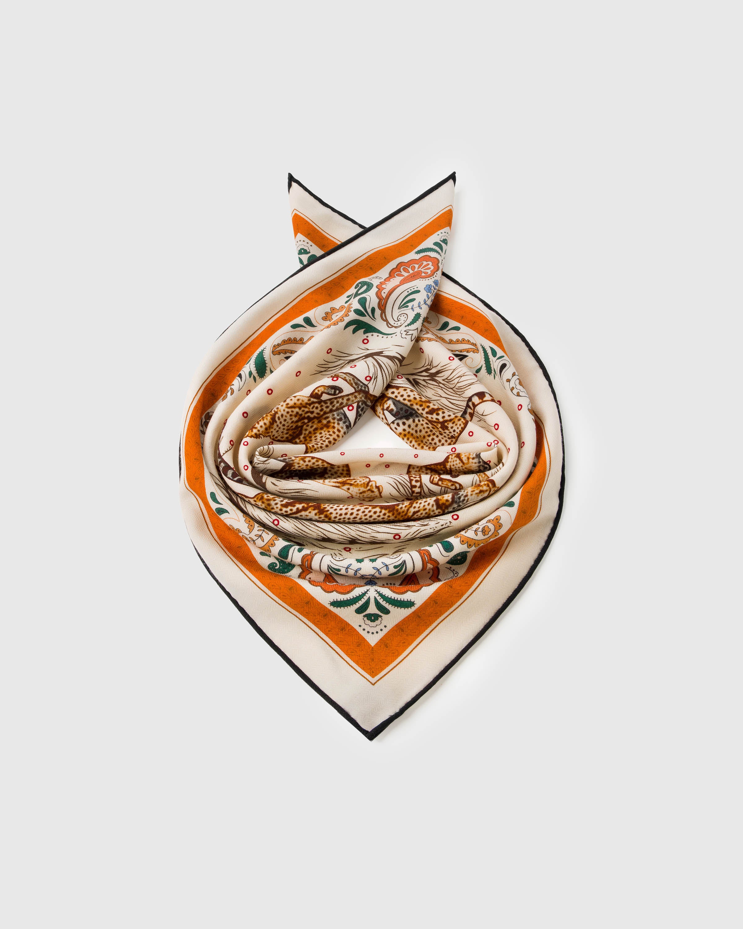 Silk cheetah scarf knotted into a soft bow showing the cream field and orange paisley frame