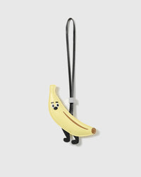 Handmade French Alran goatskin leather banana bag charm with a stitched face, legs and engraved STICKYZOO hardware