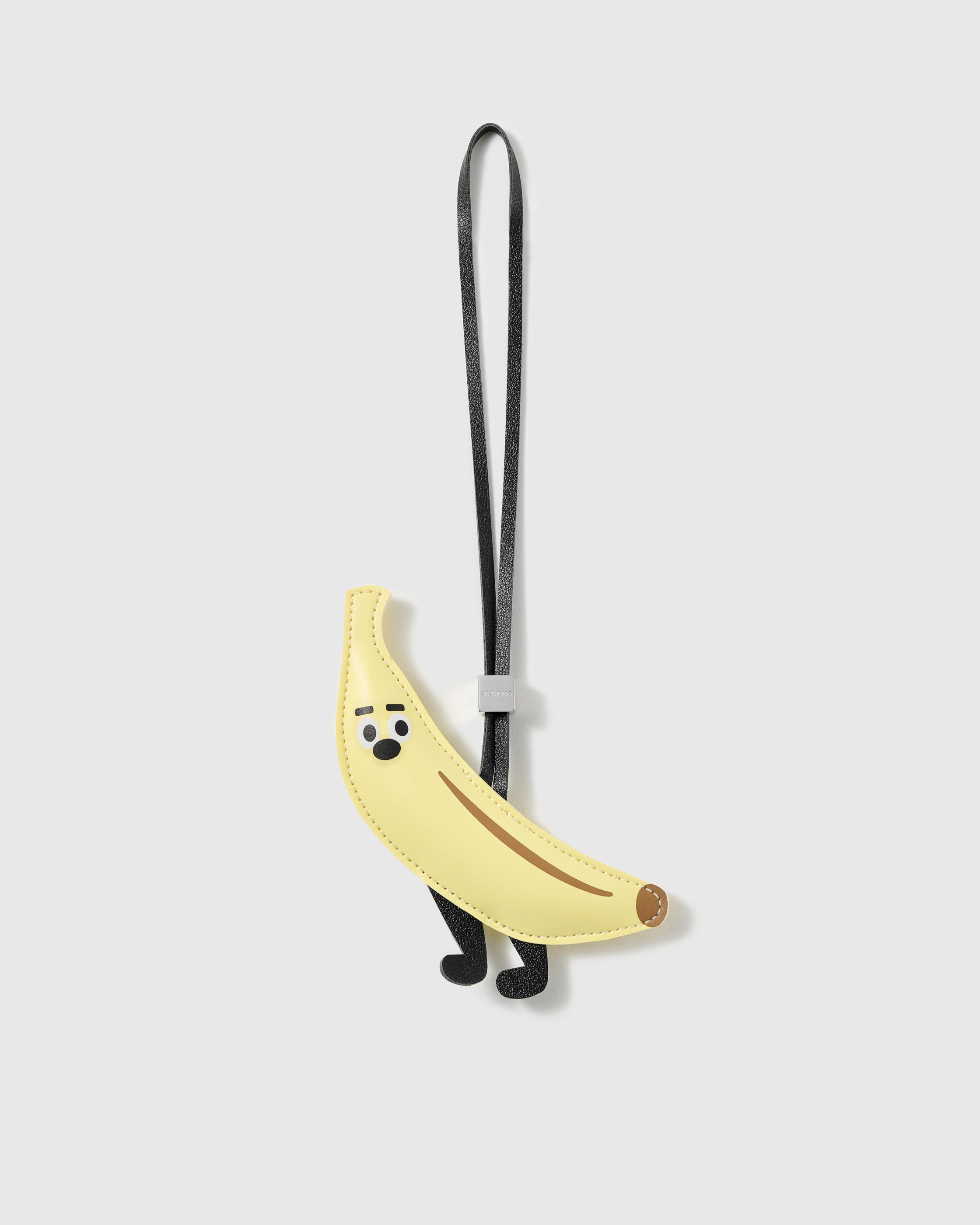 Handmade French Alran goatskin leather banana bag charm with a stitched face, legs and engraved STICKYZOO hardware