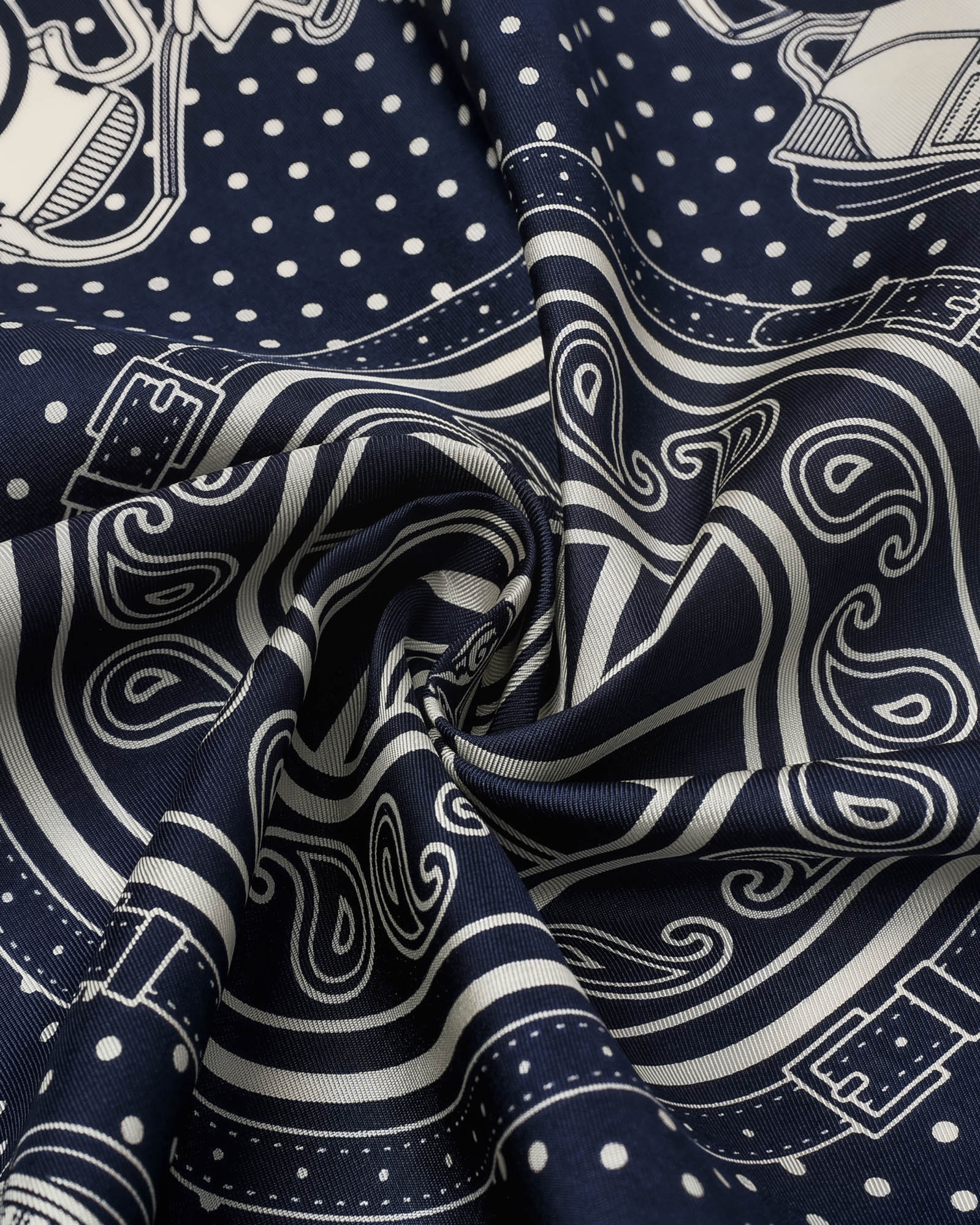 Navy bandana silk scarf coiled into a bow showing the ivory paisley and dot field by STICKYZOO