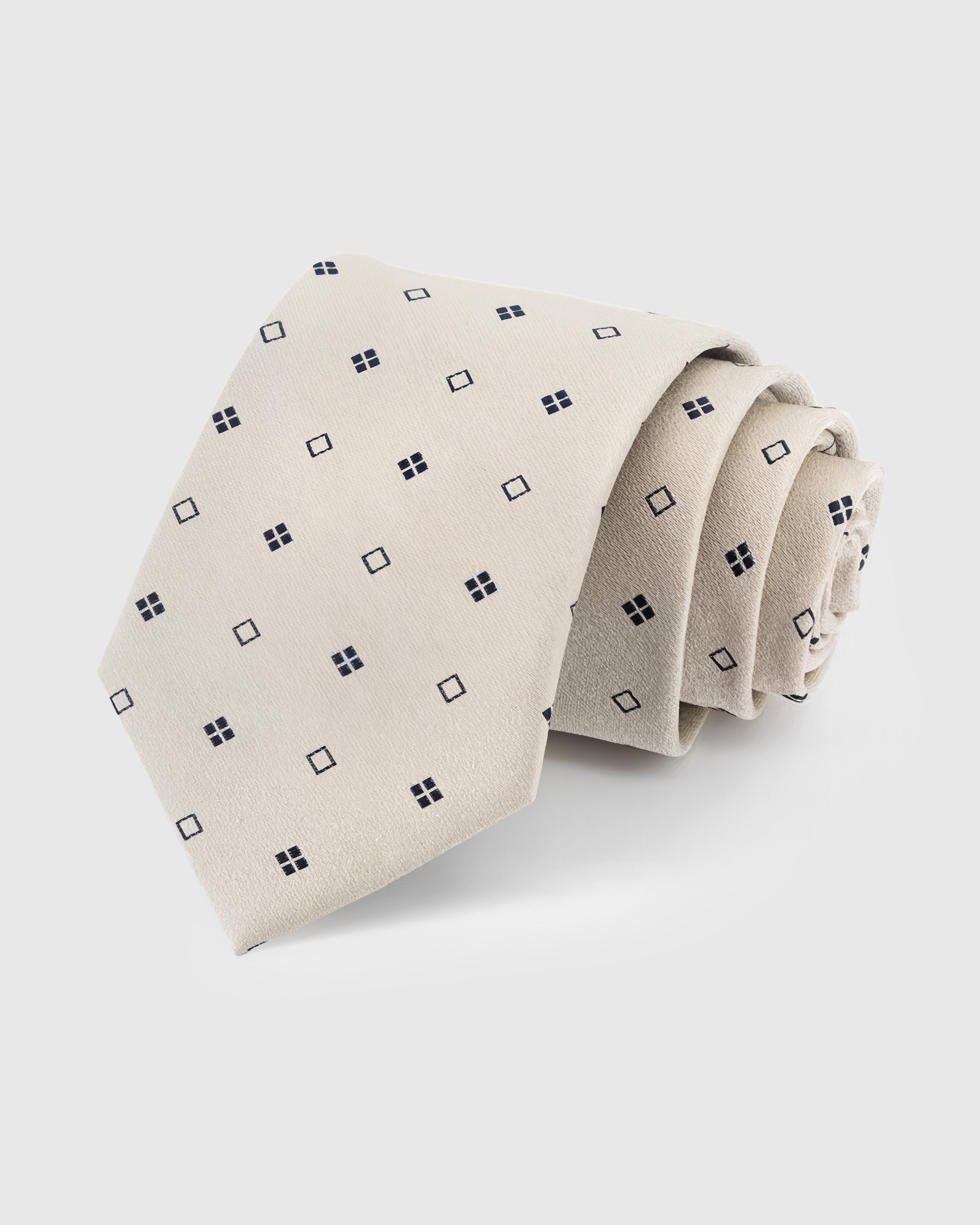 STICKYZOO Pearl Square Dot Tie in hand-embroidered mulberry silk with navy square dot motifs on off-white ground, 45° bias-cut
