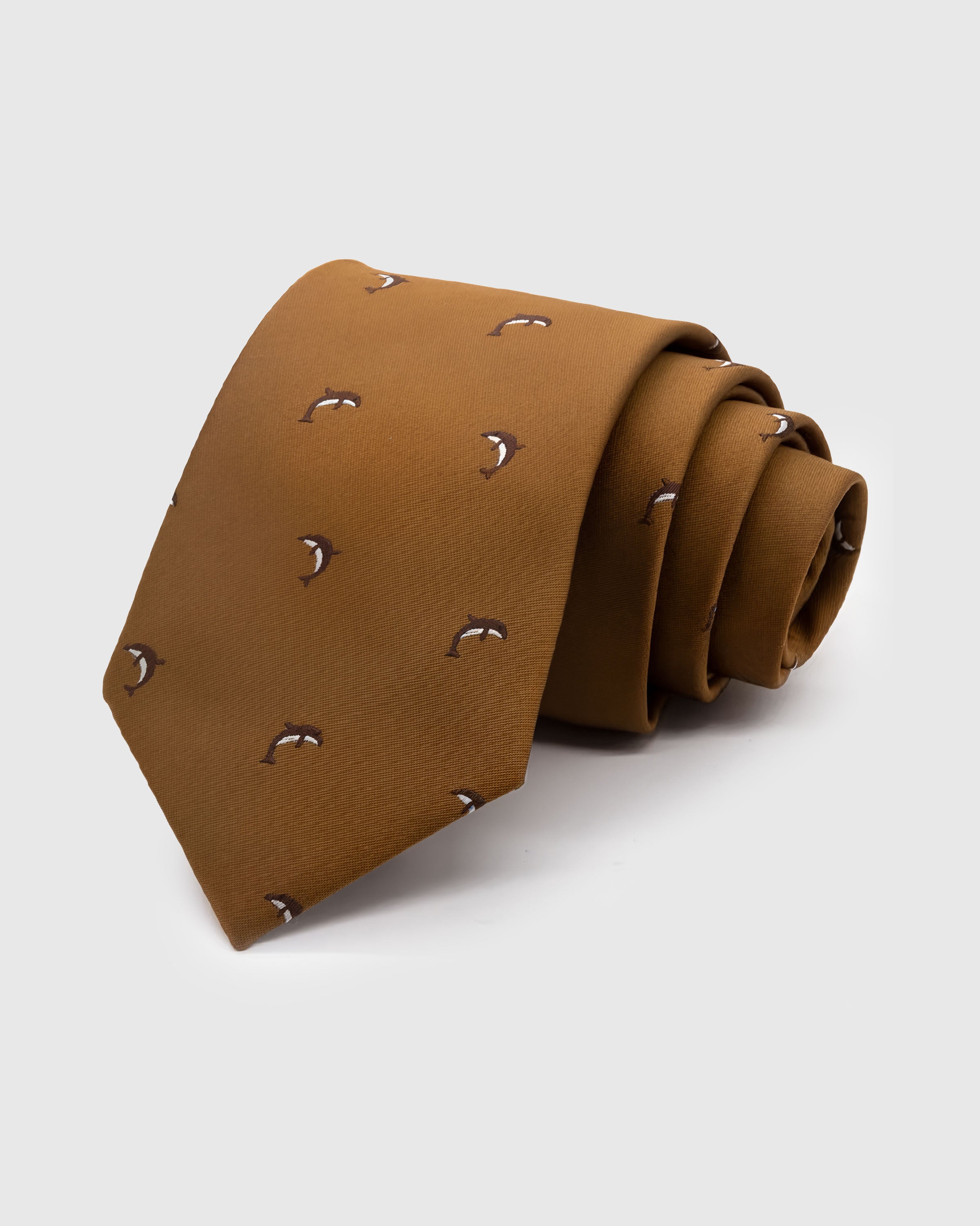 CARAMEL DOLPHIN TIE — Hand-embroidered dolphin detail on 100% mulberry silk in caramel, showing embroidery texture and silk sheen
