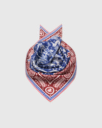 Cobalt and burgundy silk scarf coiled to show the burgundy paisley border wrapping the fold